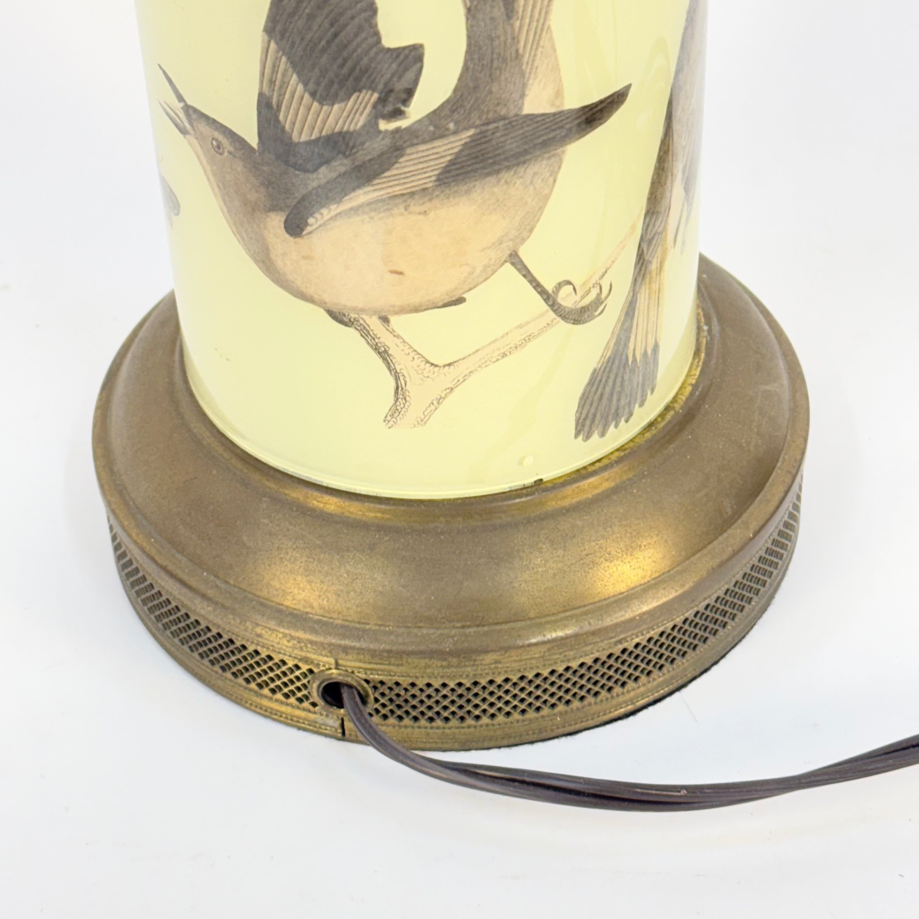 Lamp with brass base and bird illustration on a white background