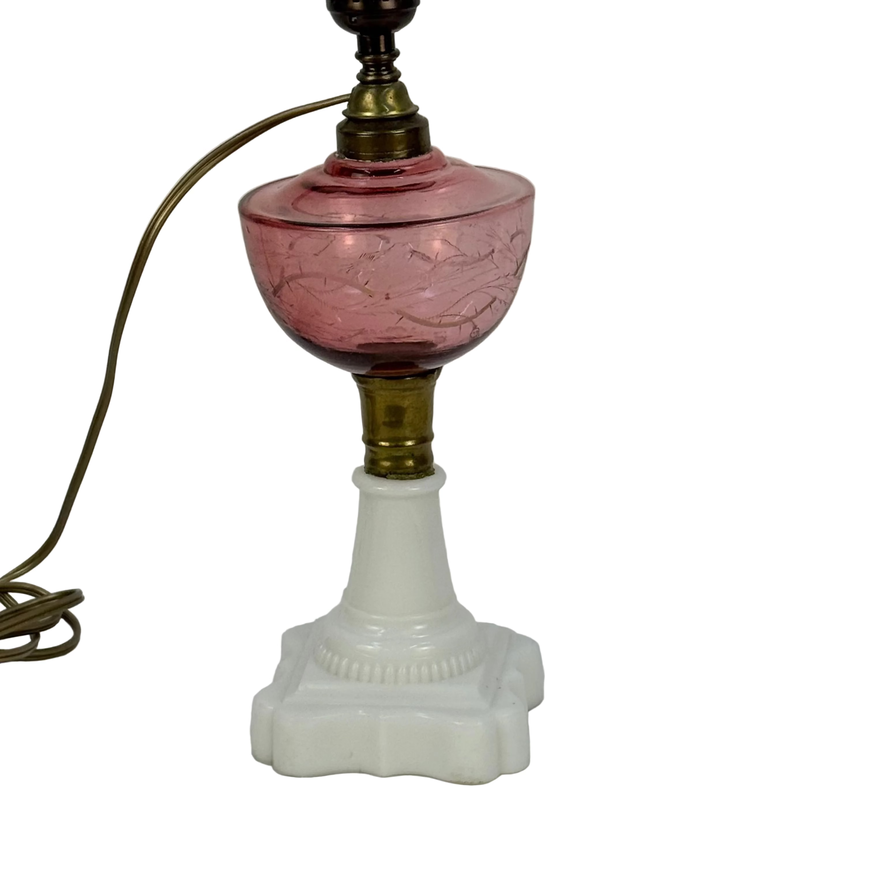 Vintage lamp with pink glass shade and white base on a plain background