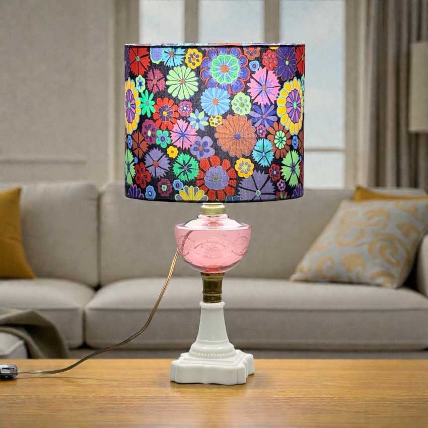 Decorative table lamp with a colorful floral shade on a wooden surface.