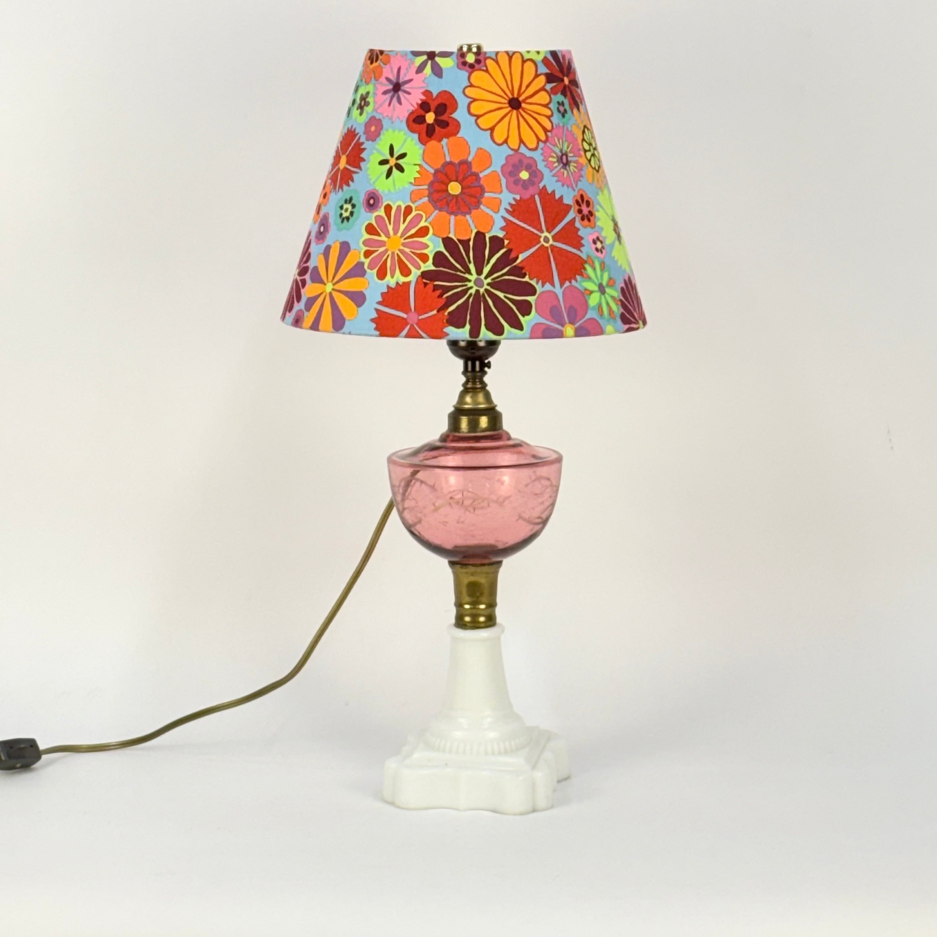 Vintage-style lamp with a colorful floral shade on a white background