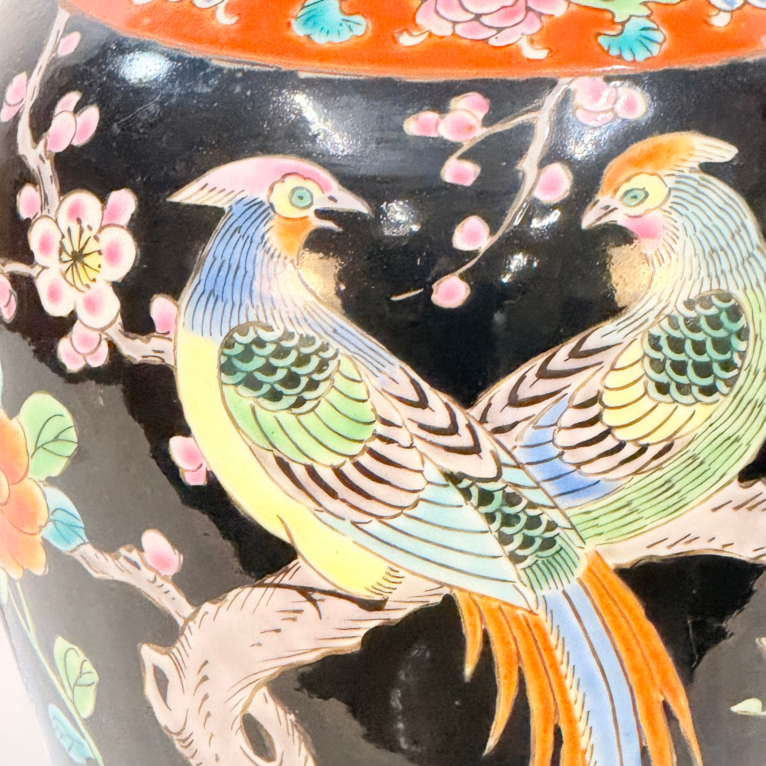 Decorative vase with colorful bird and floral design on a black background