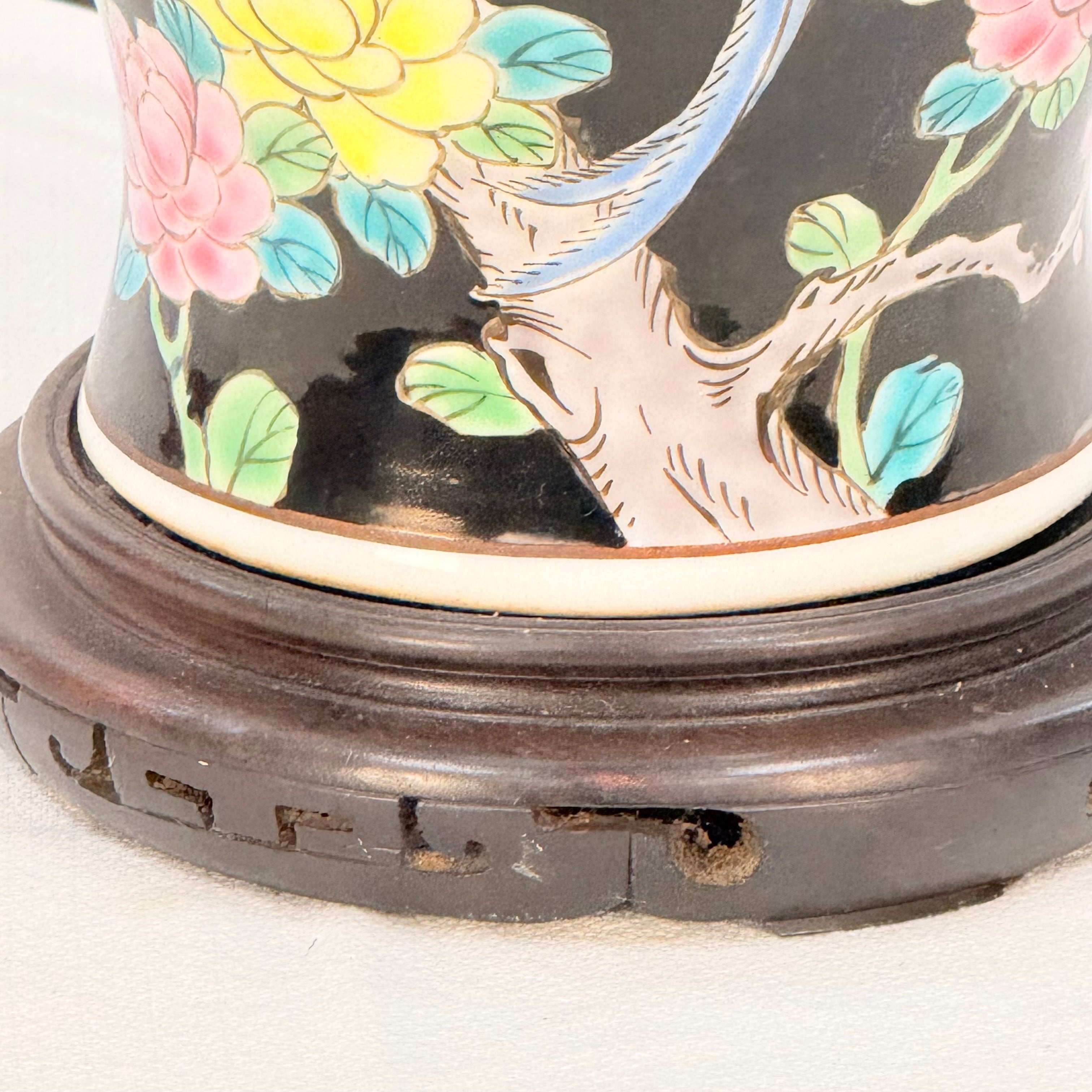 Decorative ceramic item with floral design on a wooden stand