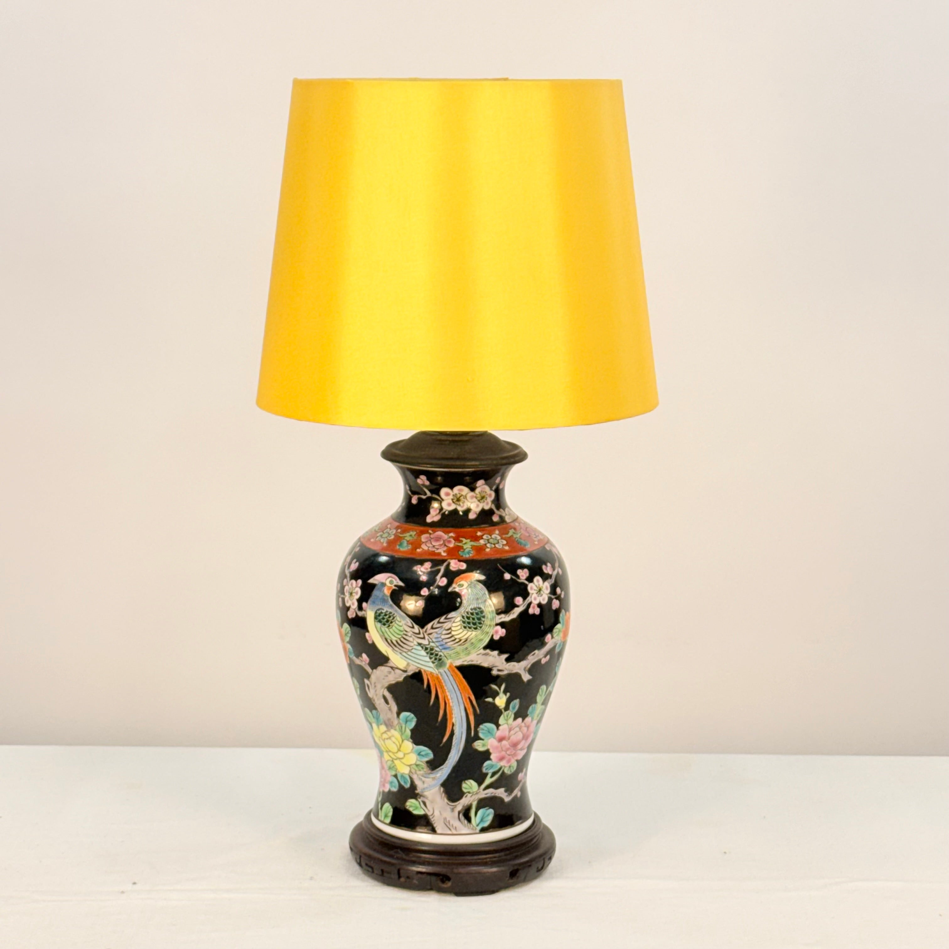 Decorative table lamp with a yellow shade on a white background
