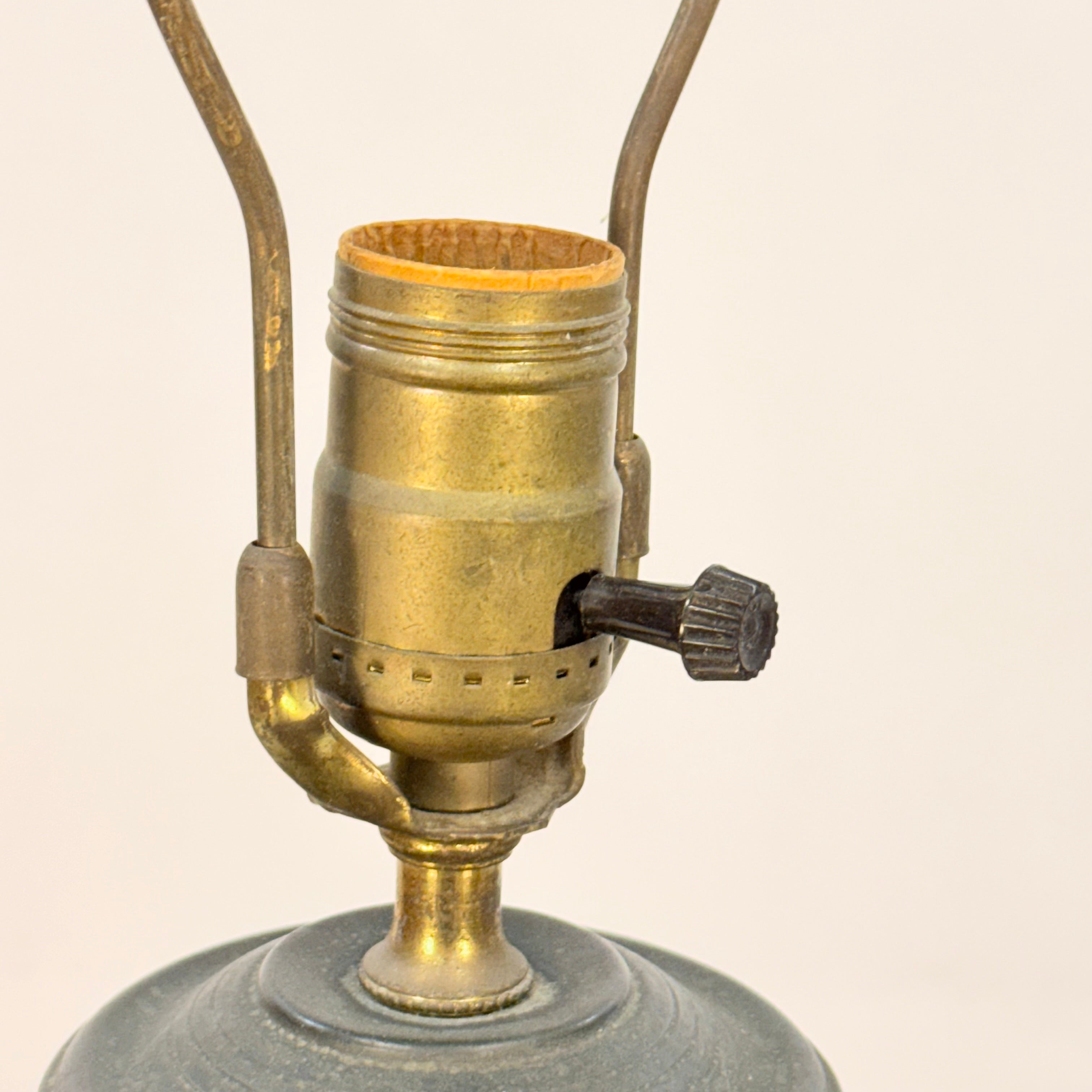 Close-up of a vintage-style lamp with brass fitting on a beige background