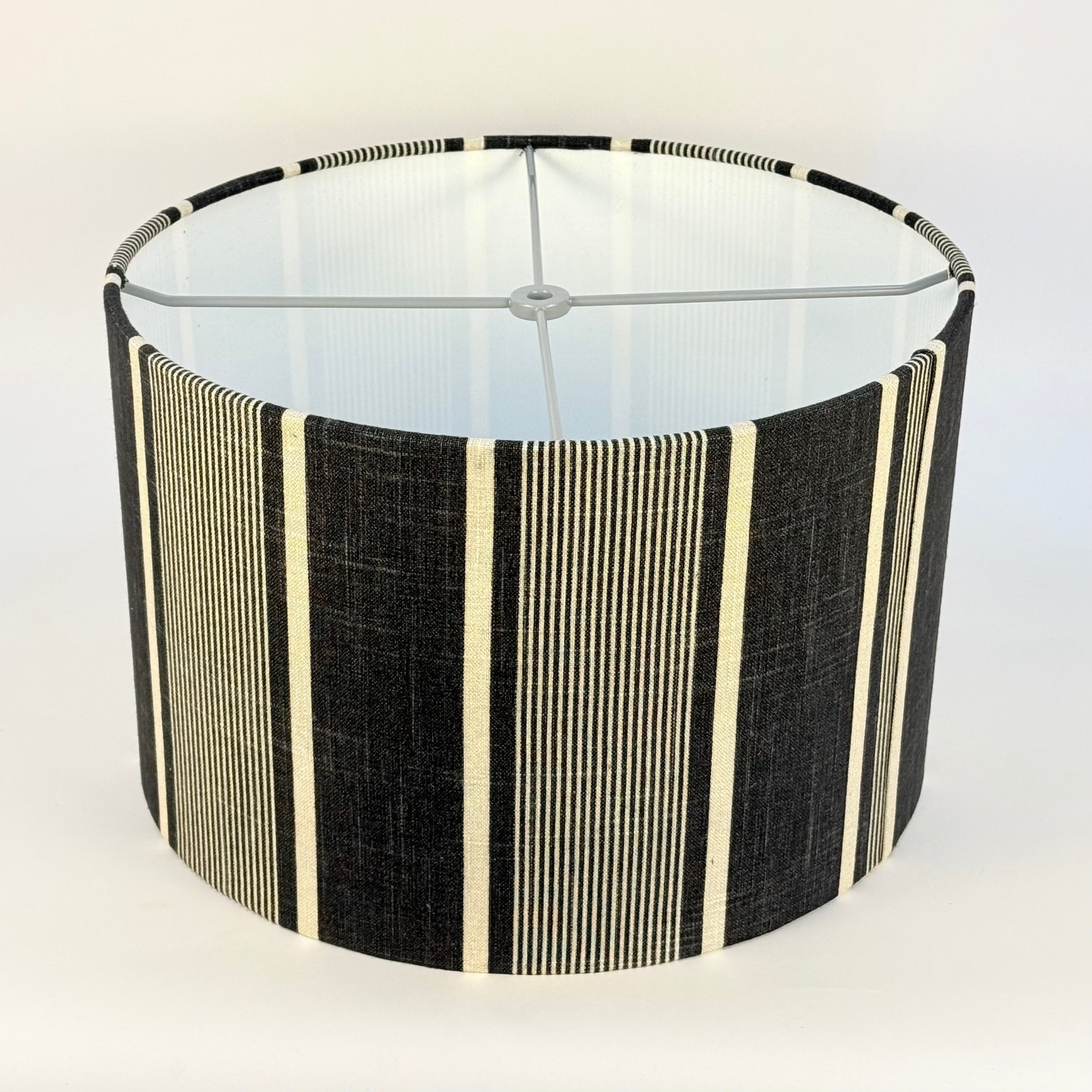 Lampshade with black and beige striped pattern on a white background