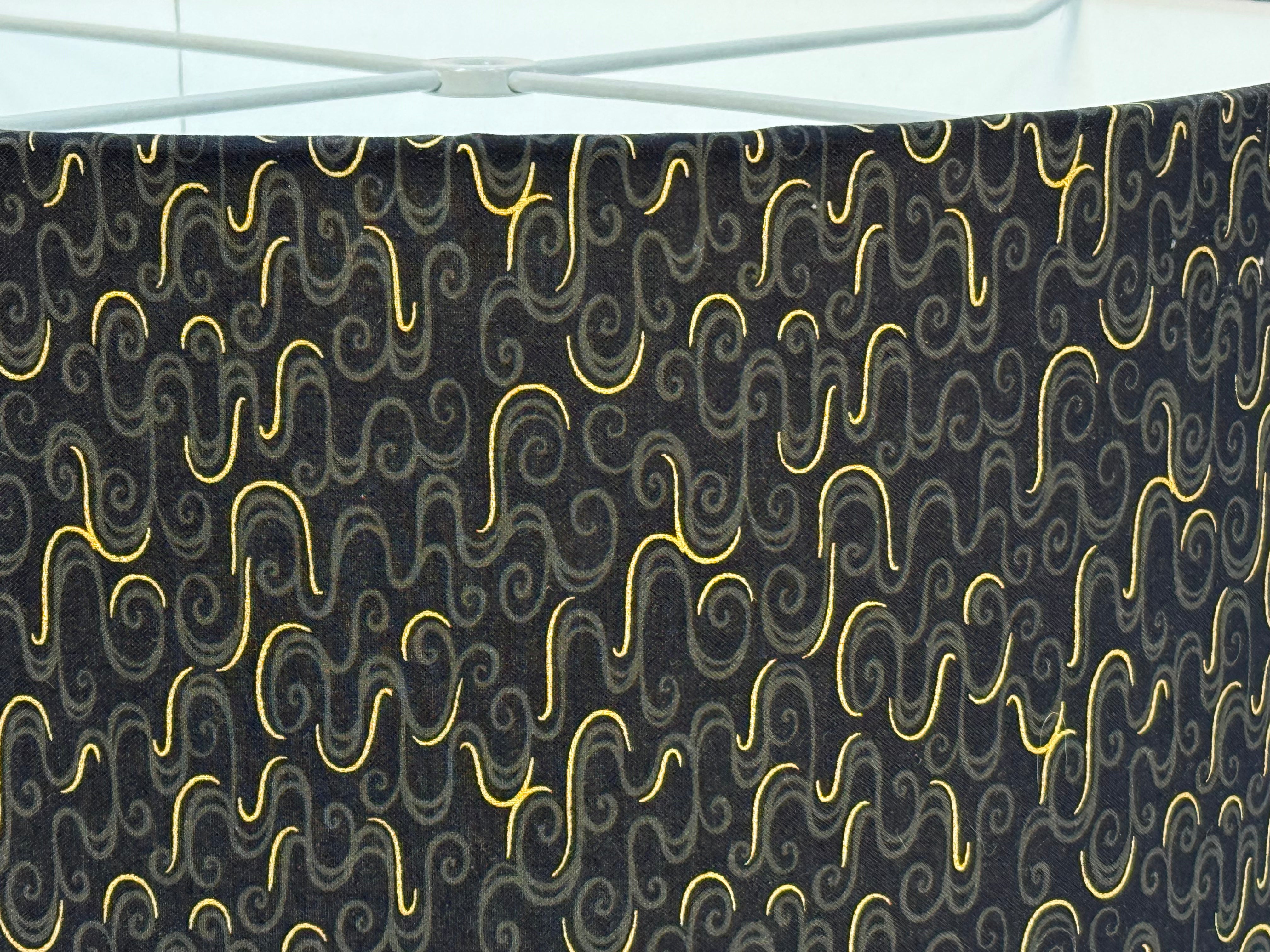 close up of lampshade covered with Black fabric with gold metallic with a wavy pattern 
