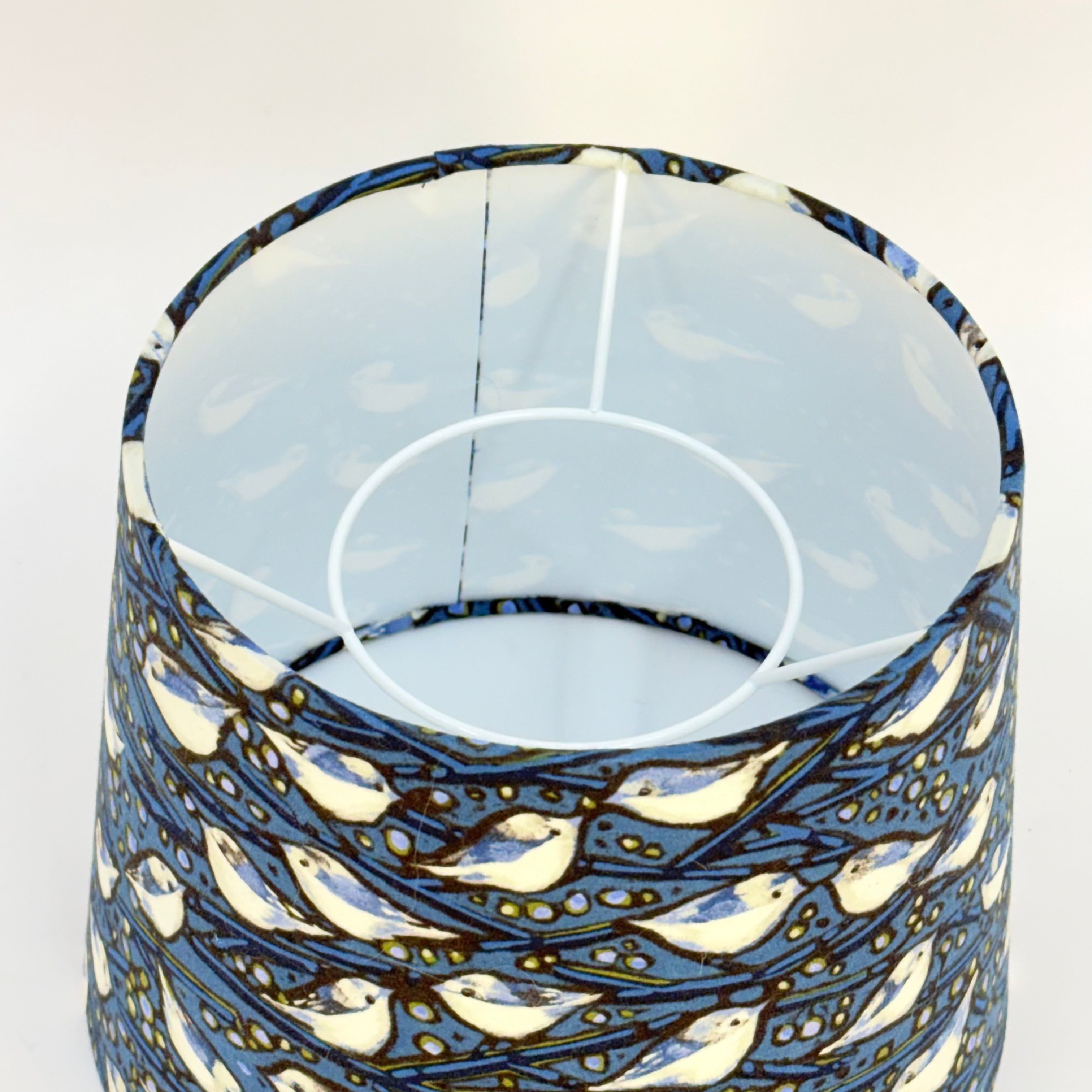 Decorative lampshade with blue and white pattern on a plain background