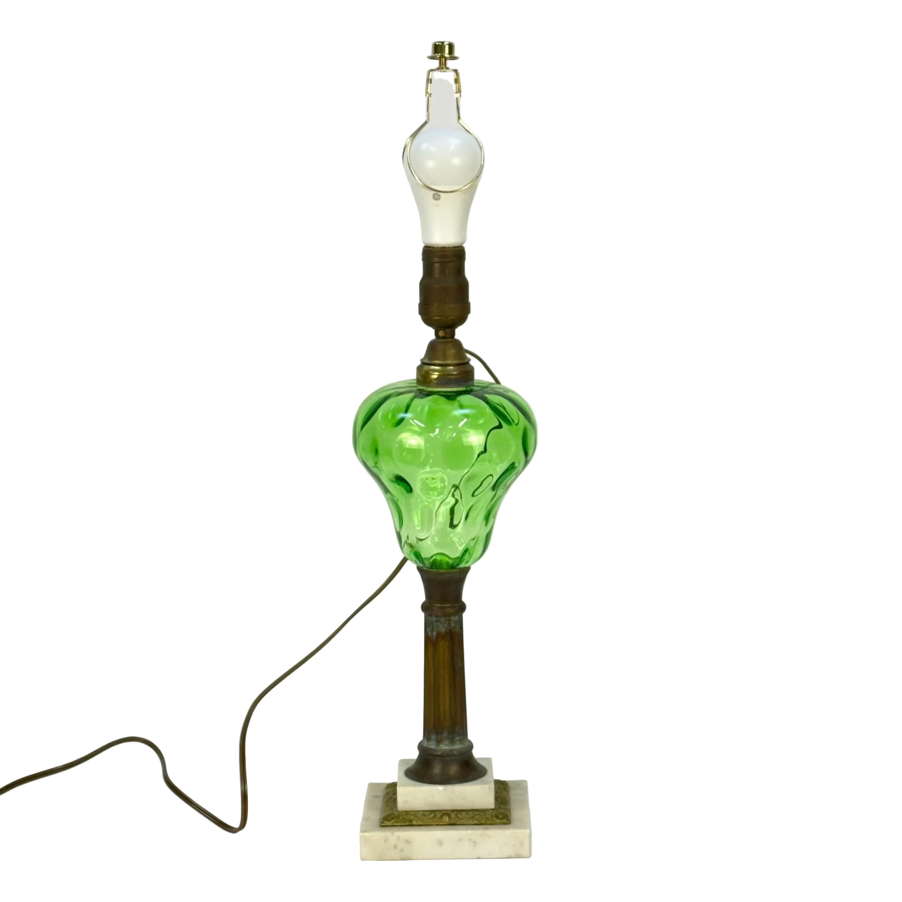 Vintage table lamp with green glass shade and white bulb on a plain background