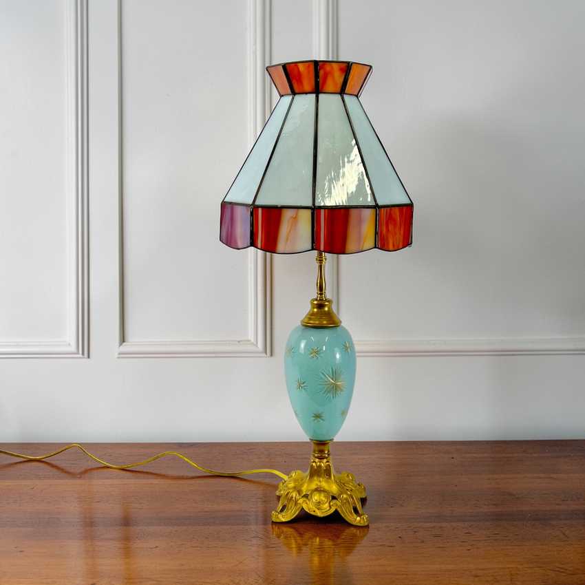 Decorative table lamp with stained glass shade on a wooden surface.