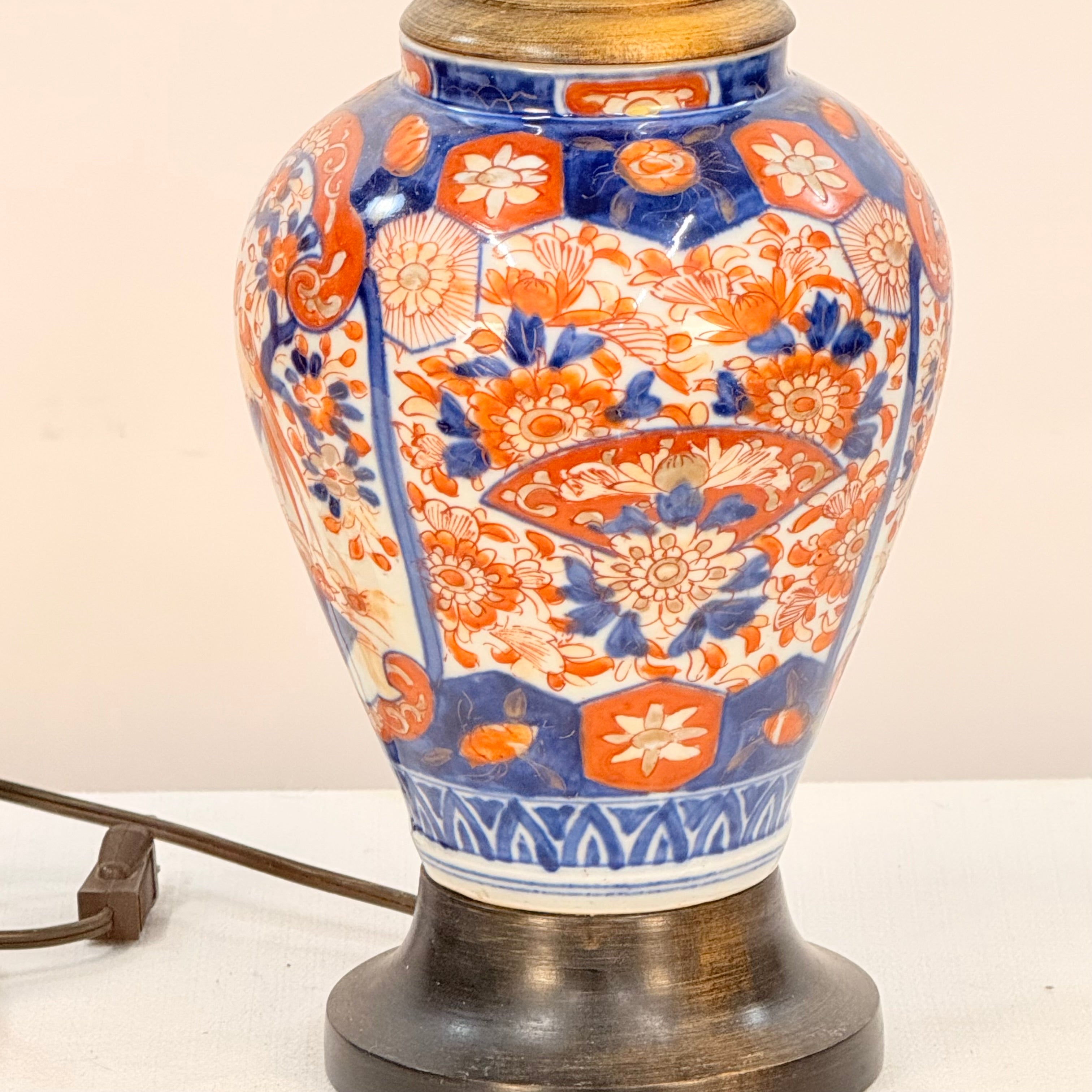 Decorative ceramic lamp with blue and orange floral patterns on a white background