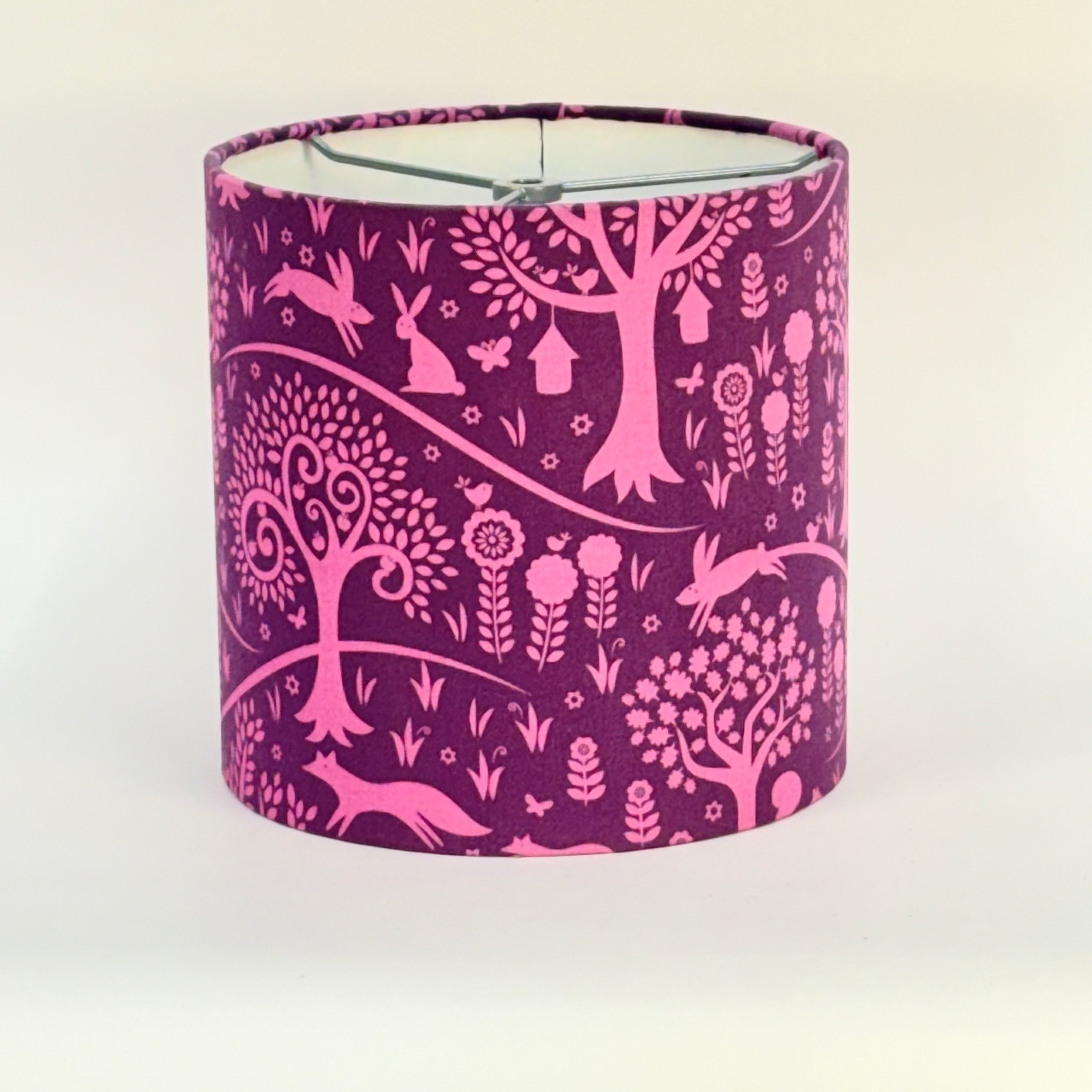 Pink animal and nature patterned lampshade on a white background