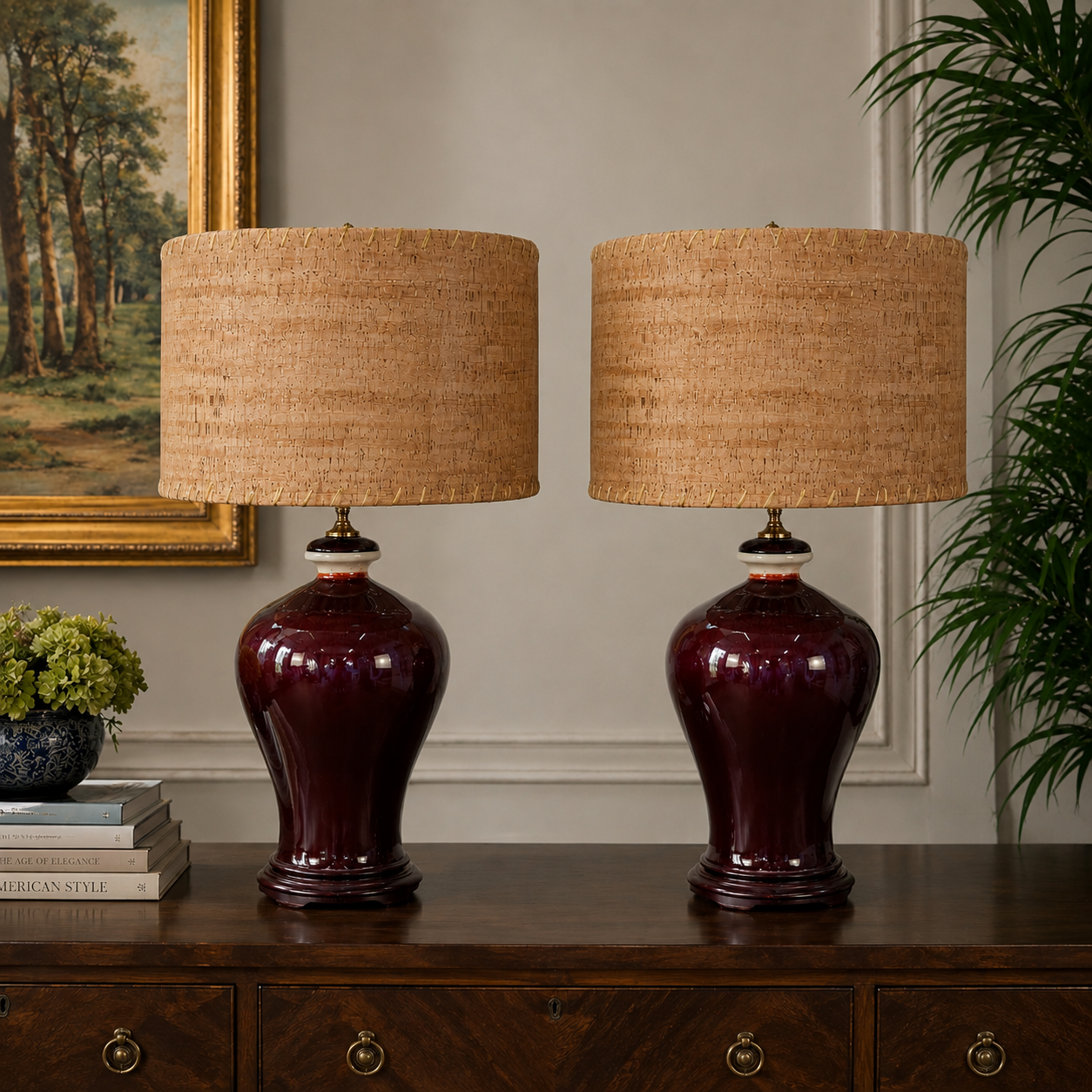 Two matching table lamps with dark burgundy glazed ceramic bases and natural beige woven drum shades, displayed on a wooden console table in an interior setting.