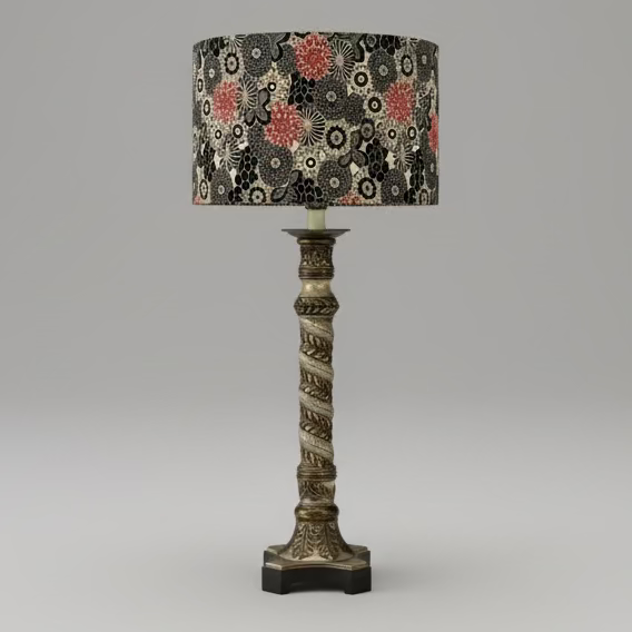 Tall Uttermost lamp with a black and red retro floral drum shade on a white background