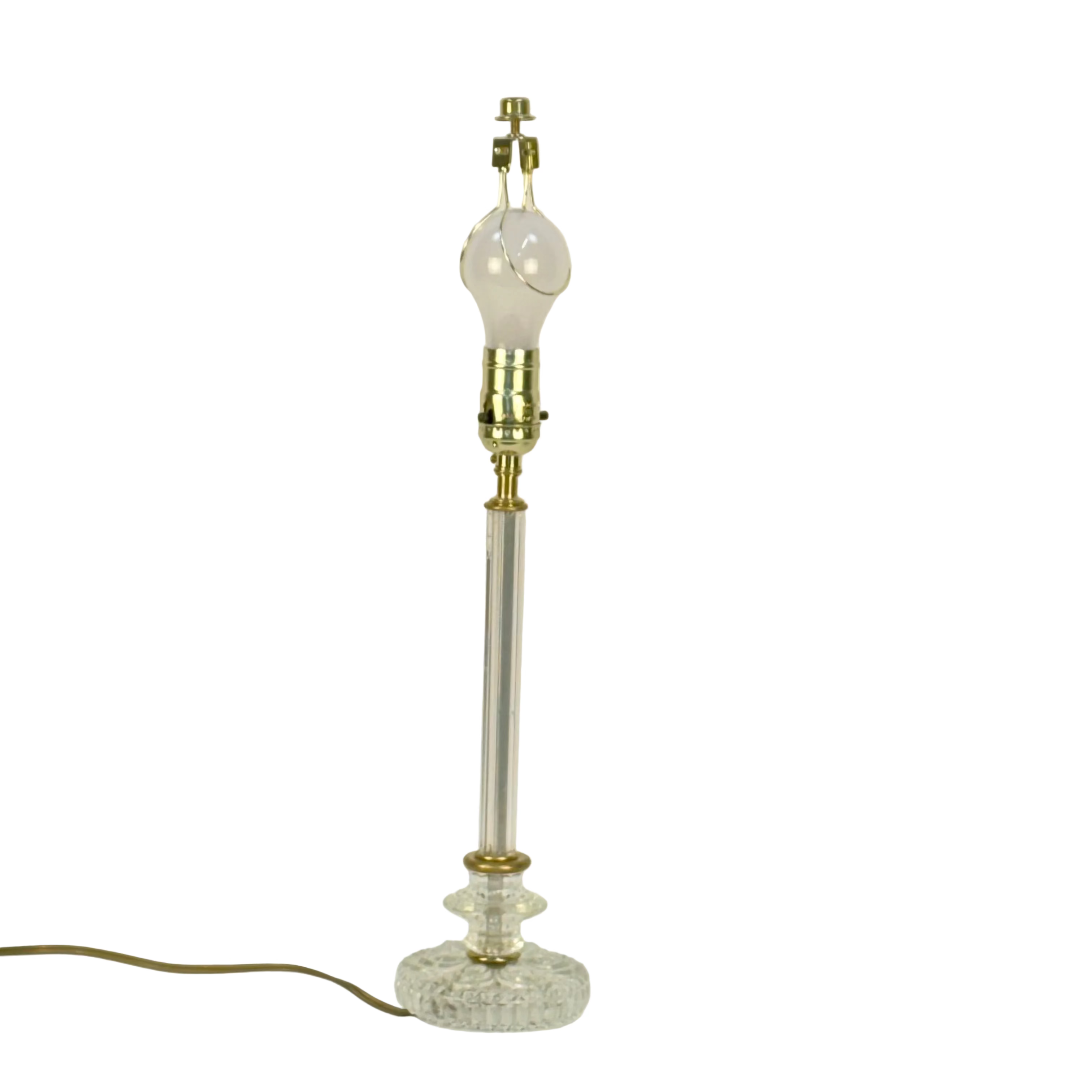 Vintage-style table lamp with a clear glass base and brass accents on a light gray background