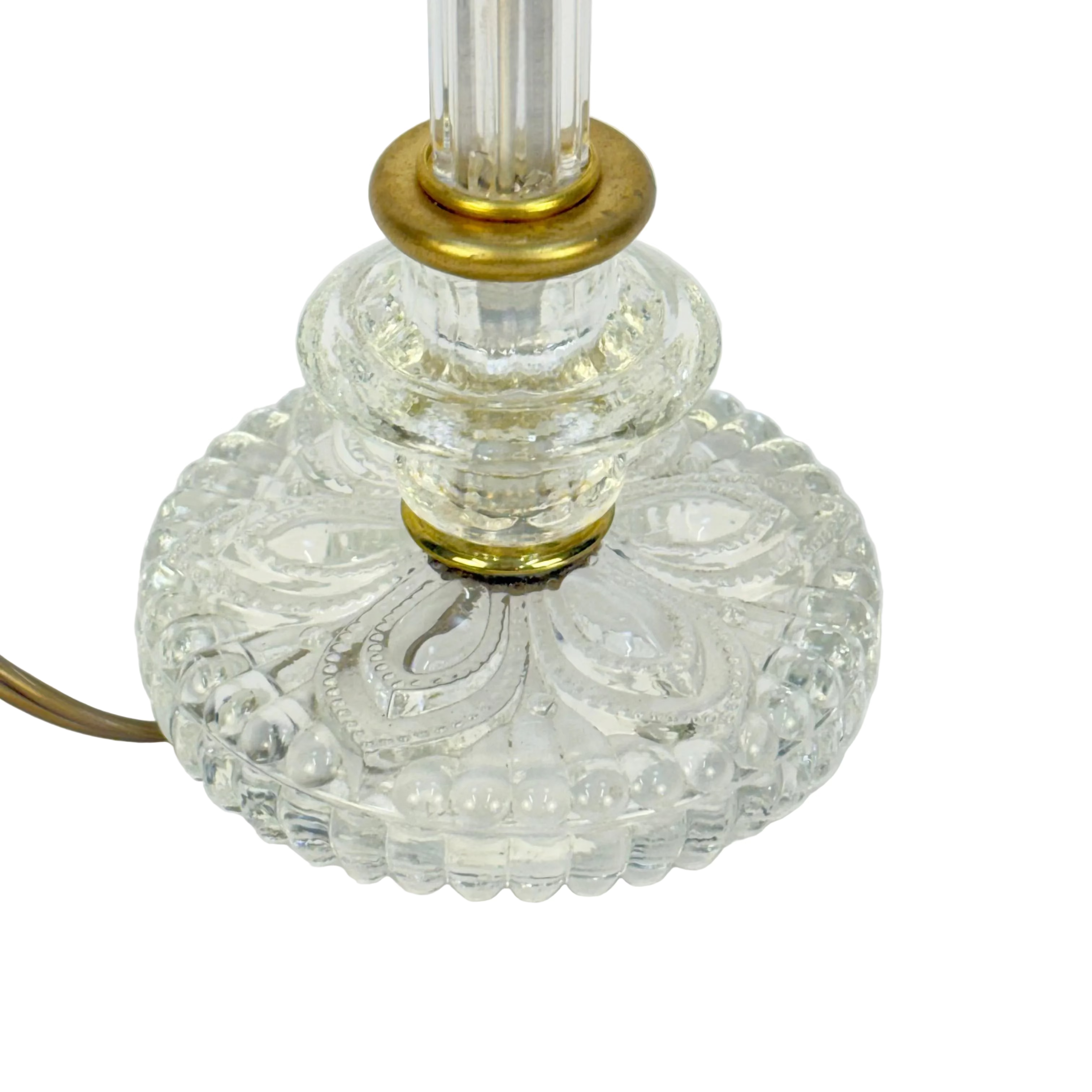 Close-up of a decorative glass lamp base with gold accents on a white background
