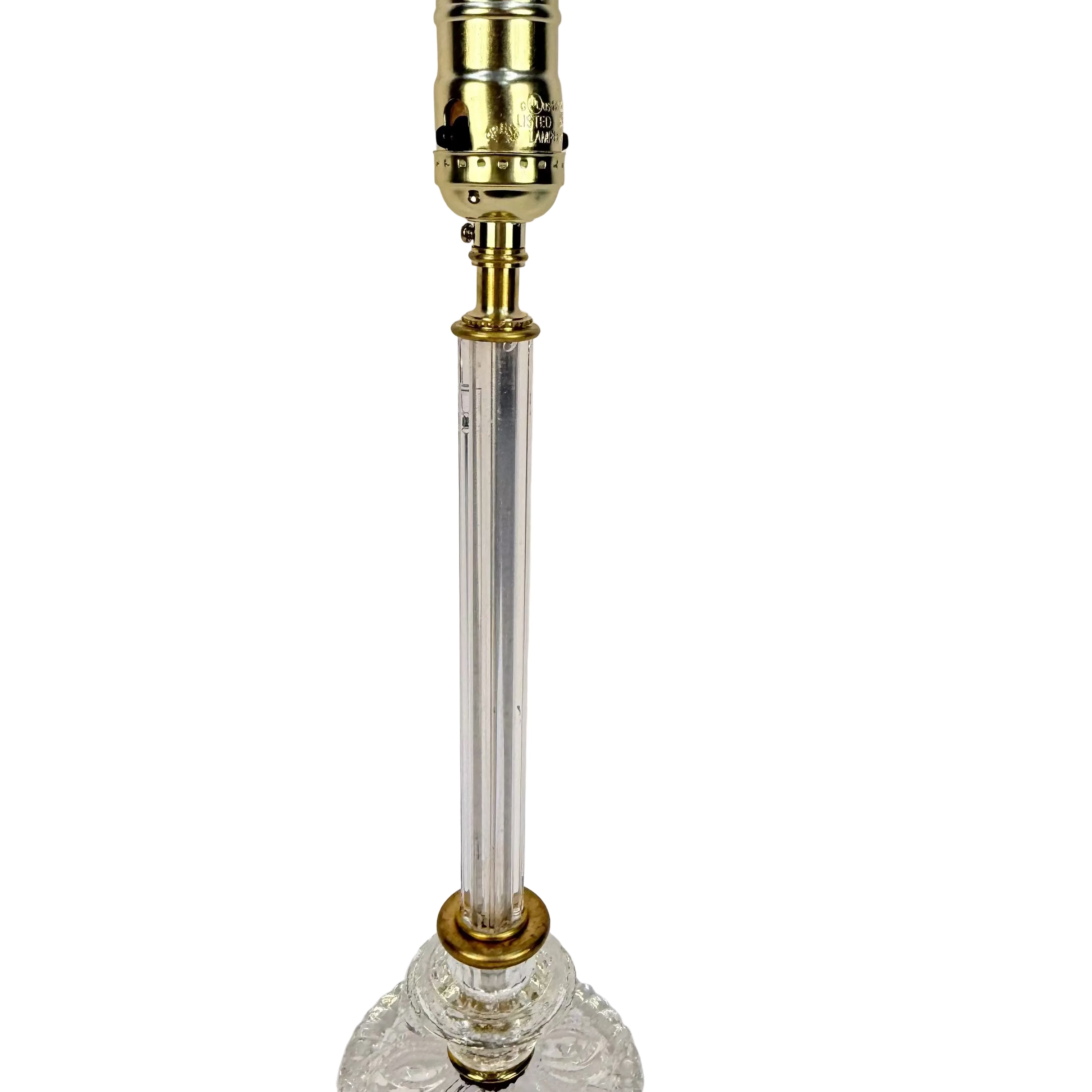 Clear glass lamp with gold metal base on a white background