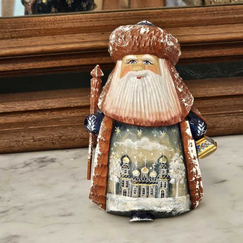 small hand carved wooden figuring of stout bearded older man with Russian Orthodox style building painted on robe in Palekh style