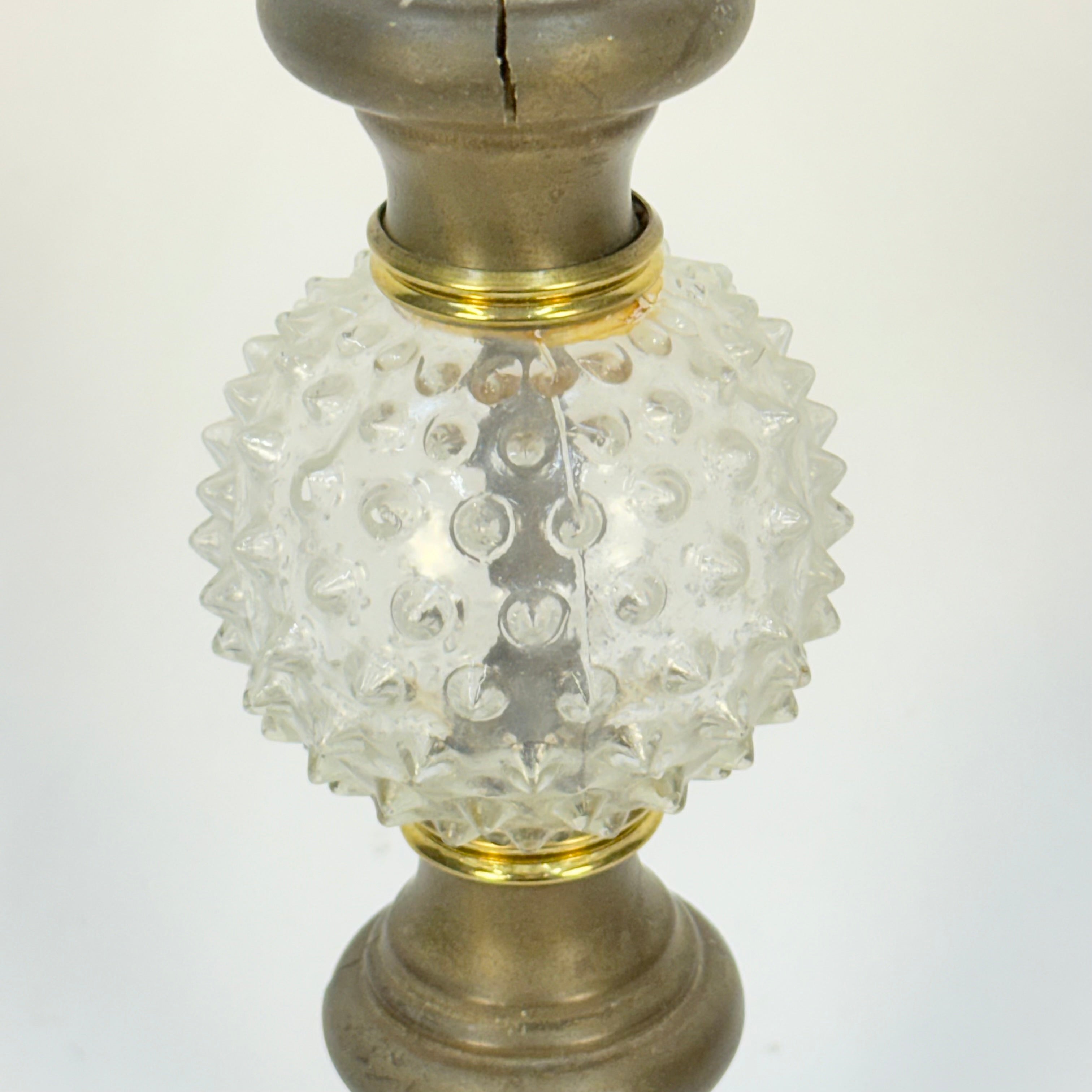 Decorative lamp with textured glass shade and metallic base on a white background