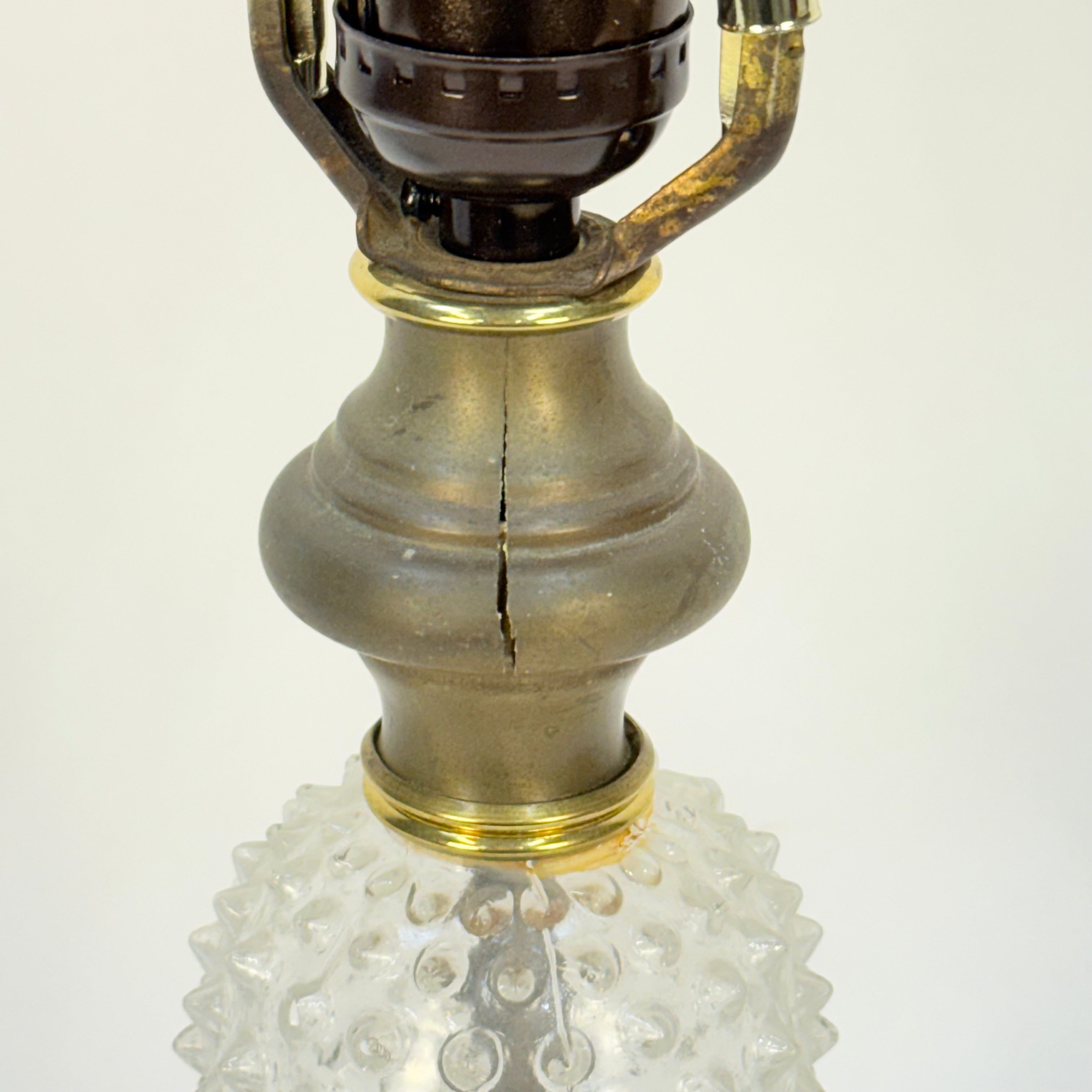 Vintage-style oil lamp with brass and glass design on a white background