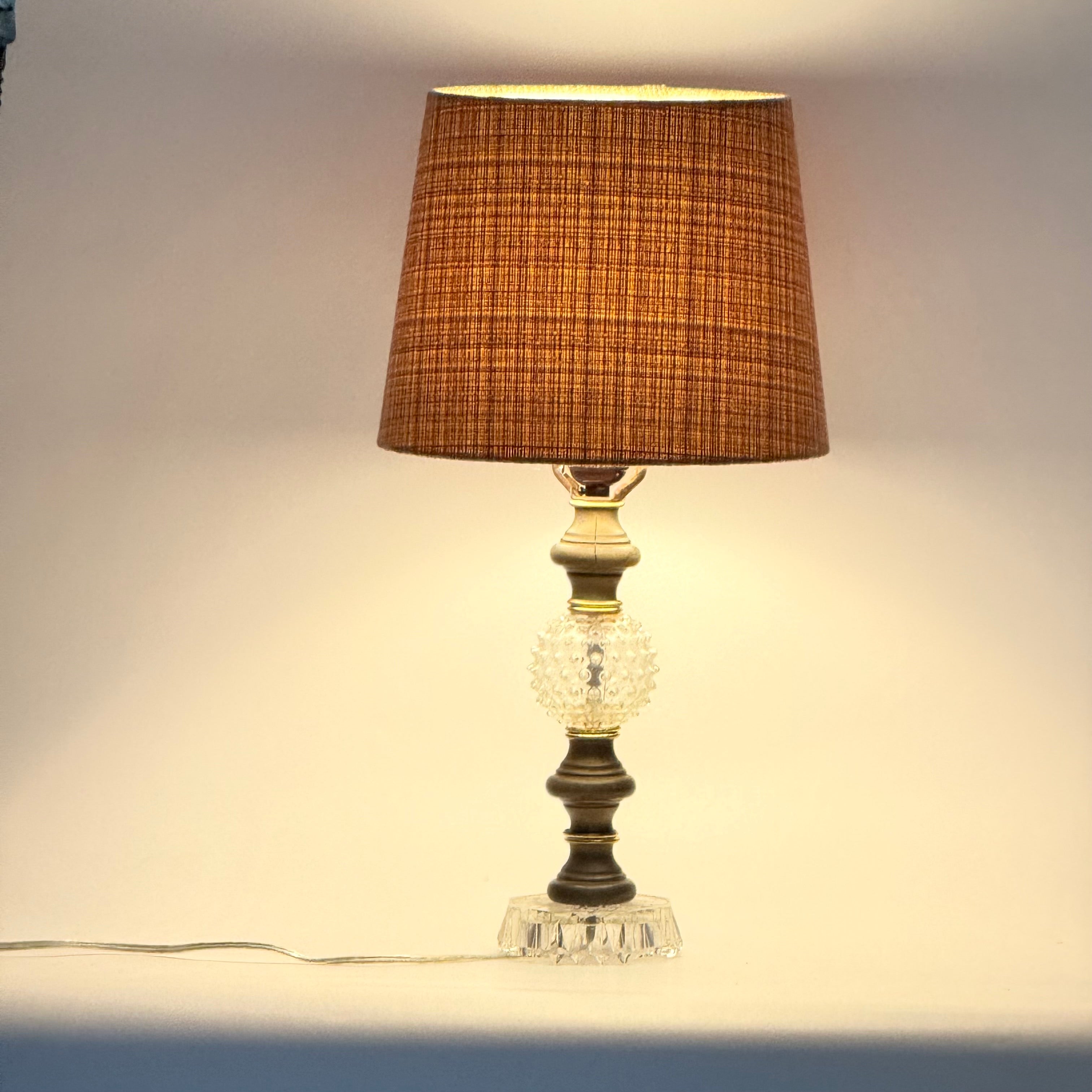 Decorative table lamp with a brown textured shade on a neutral background