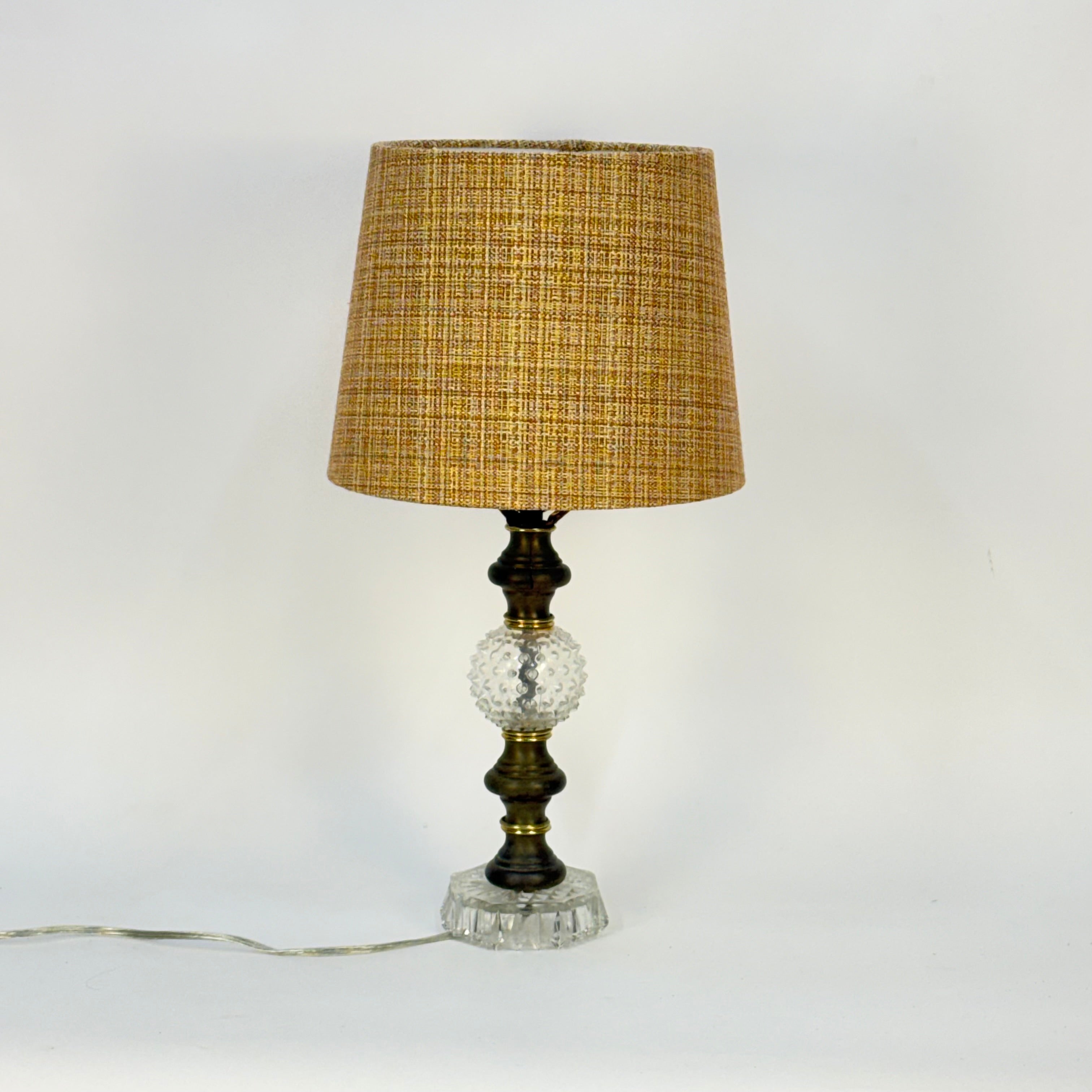 Table lamp with a textured brown shade and decorative base on a white background