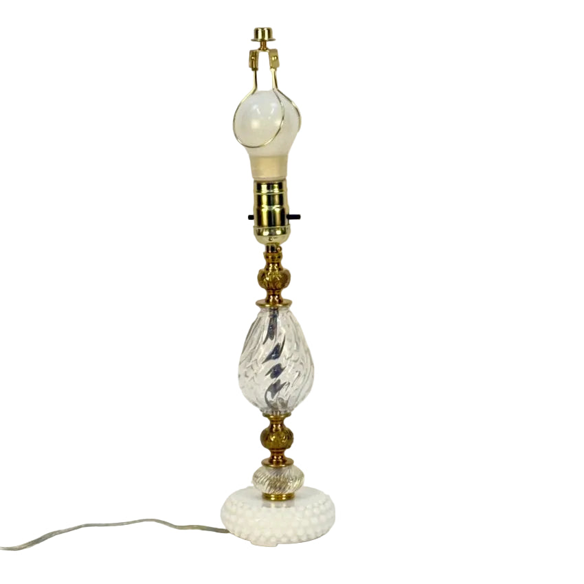 Decorative table lamp with glass and brass elements on a white background