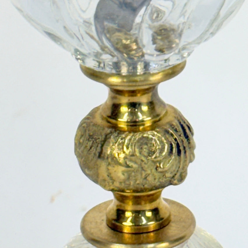 Decorative lamp with gold base and clear glass shade on a white background