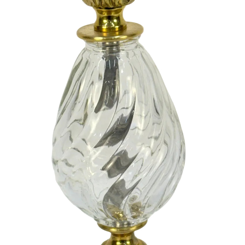 Clear glass lamp with gold base and top on a white background