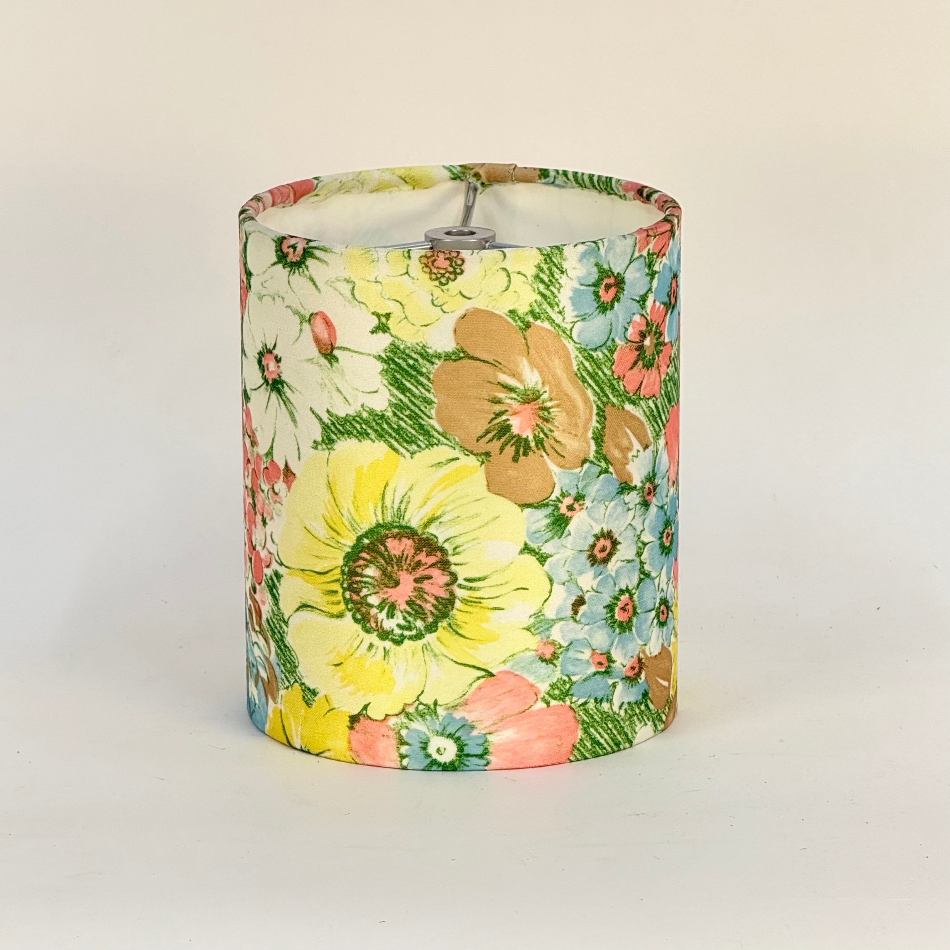 Floral-patterned cylindrical lampshade on a plain background