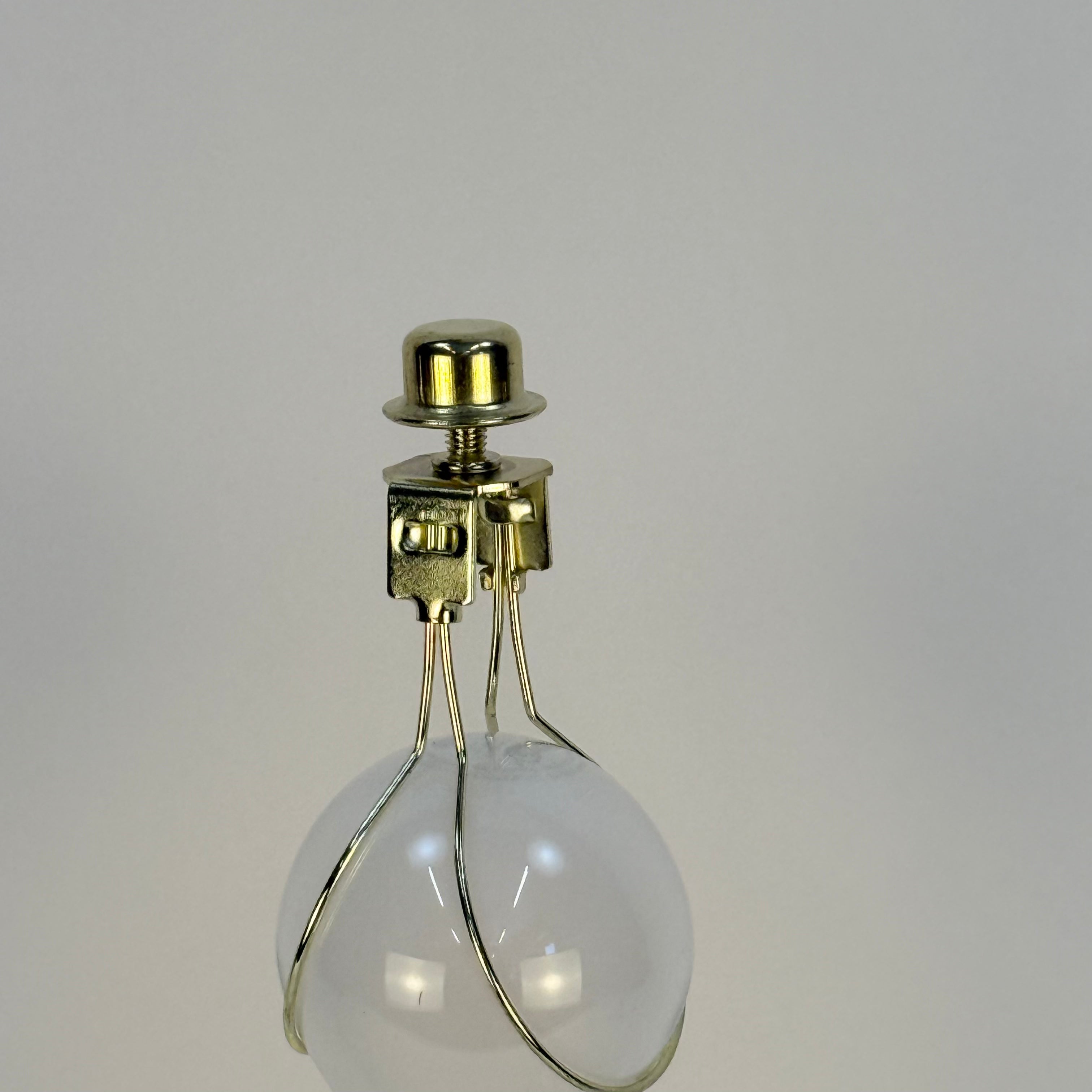 Clear light bulb with gold base on a gray background