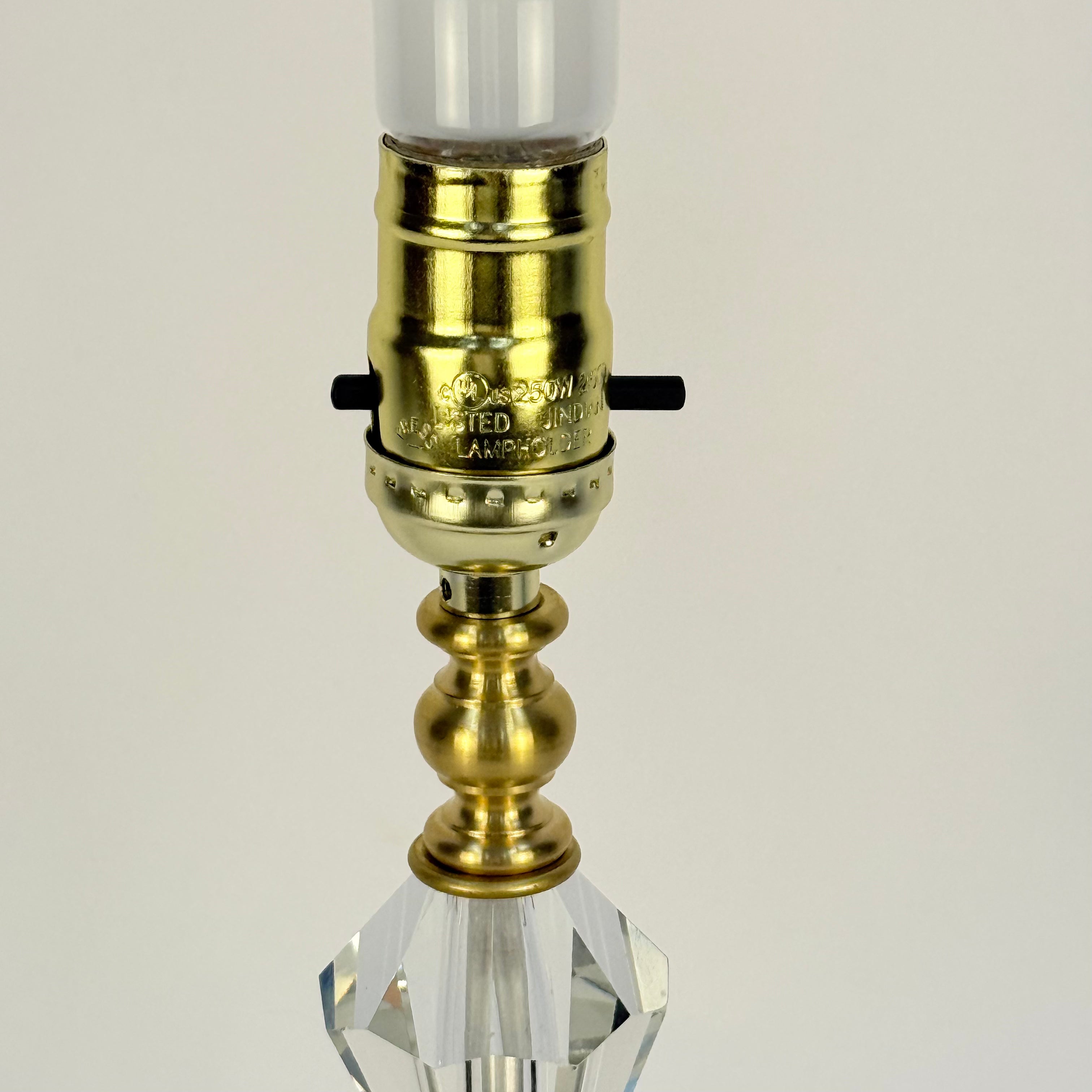 Gold and crystal lamp base on a beige background