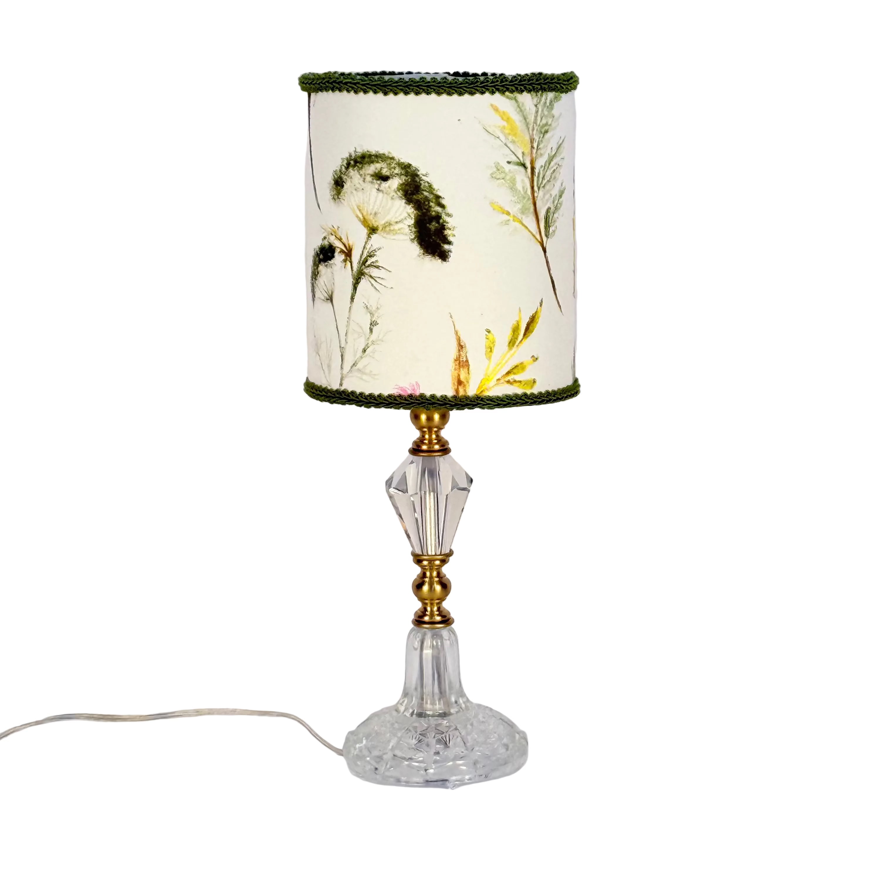 Decorative lamp with floral design on the shade against a white background