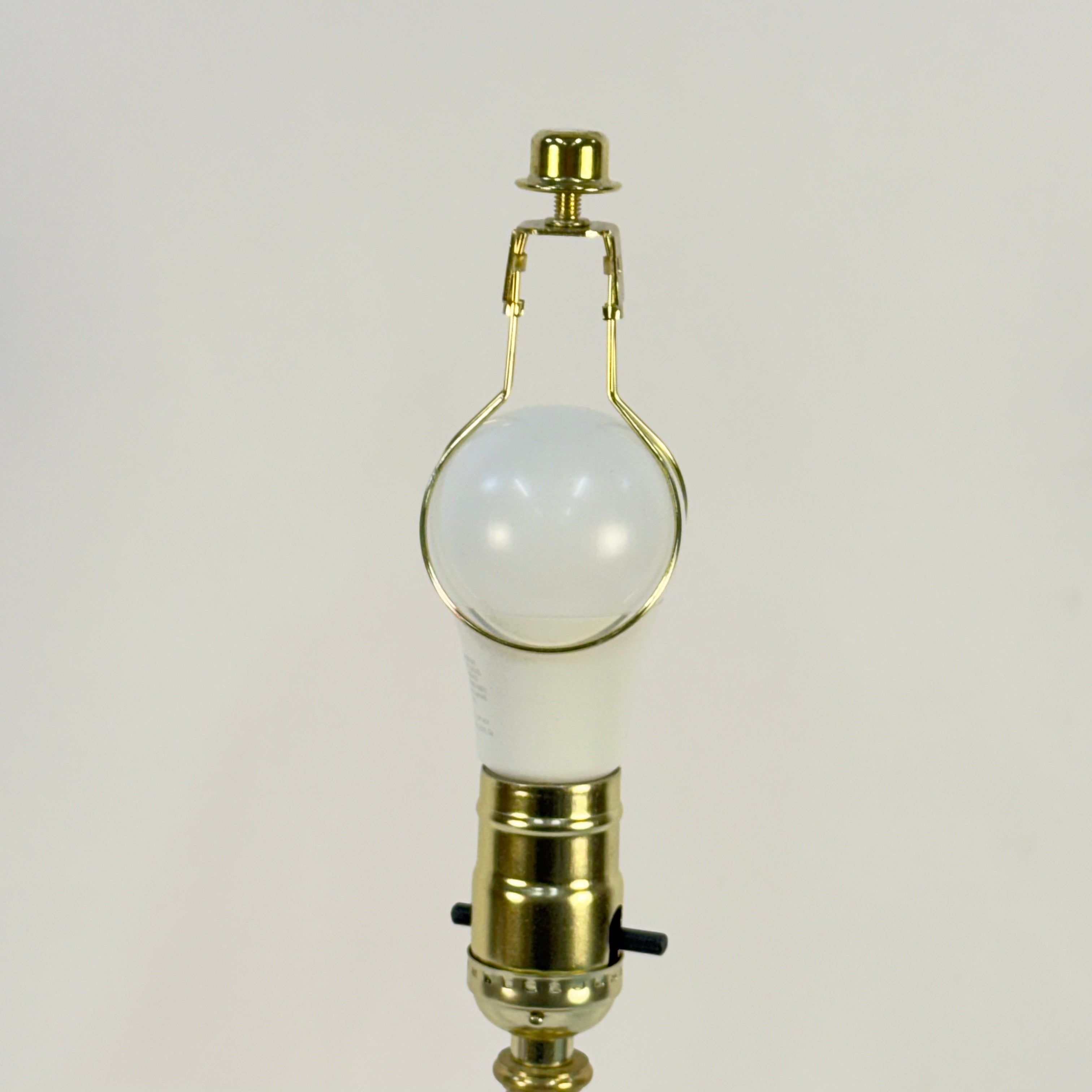 Light bulb with gold base on a plain background