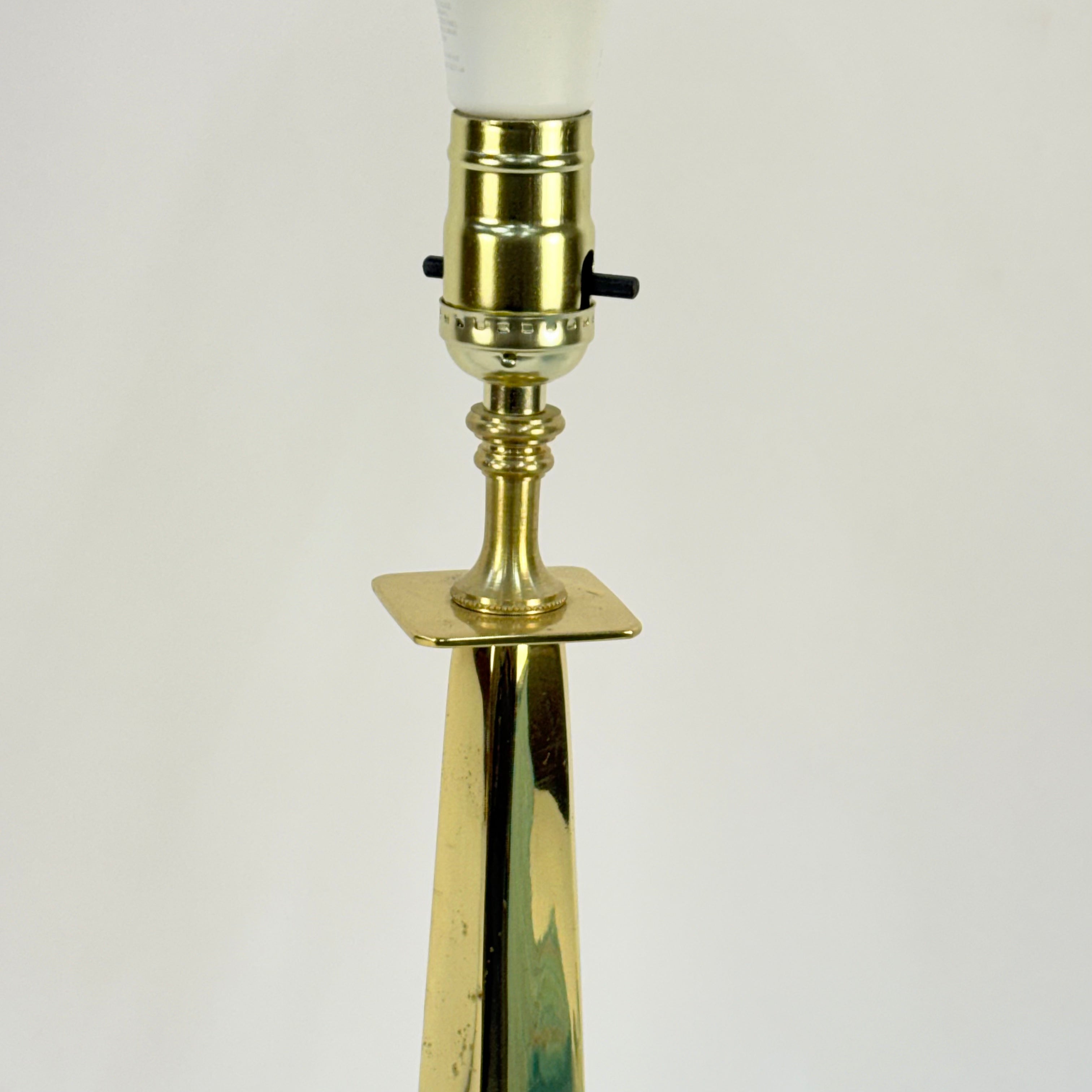 Brass lamp with a white bulb on a light beige background