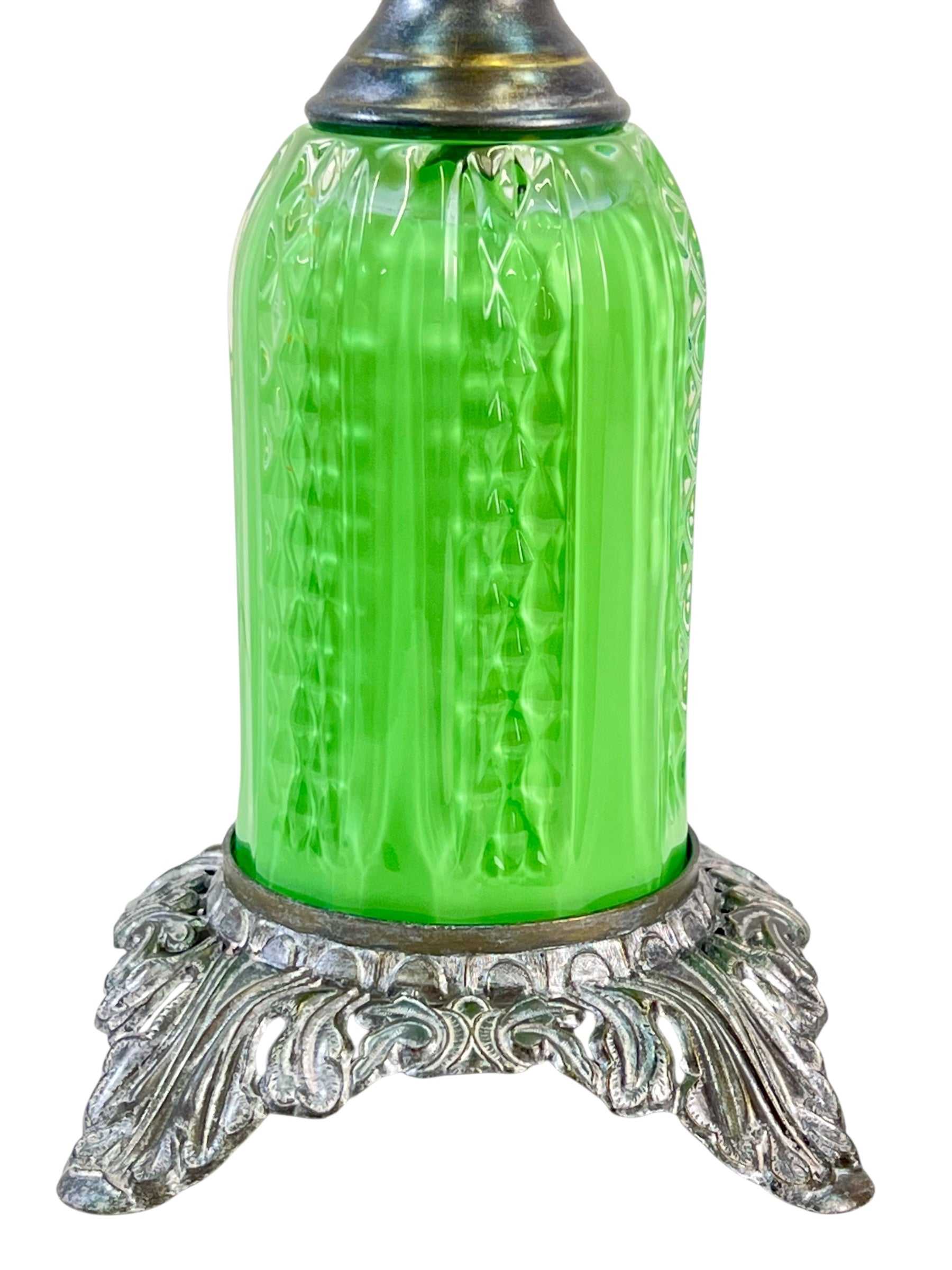 Decorative lamp with a green glass shade and silver base on a white background