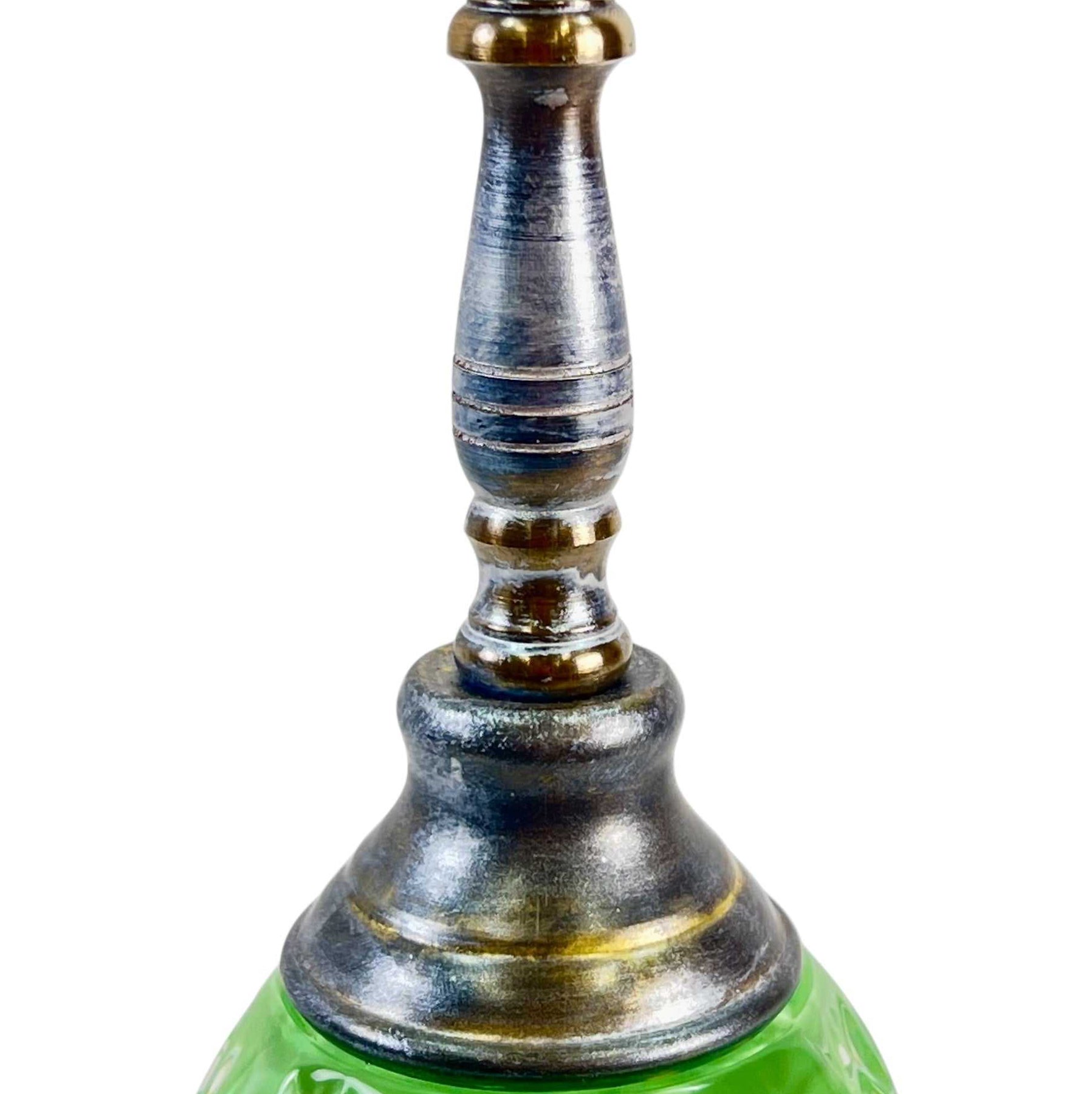 Decorative lamp with green base, silver and gold accents on a white background