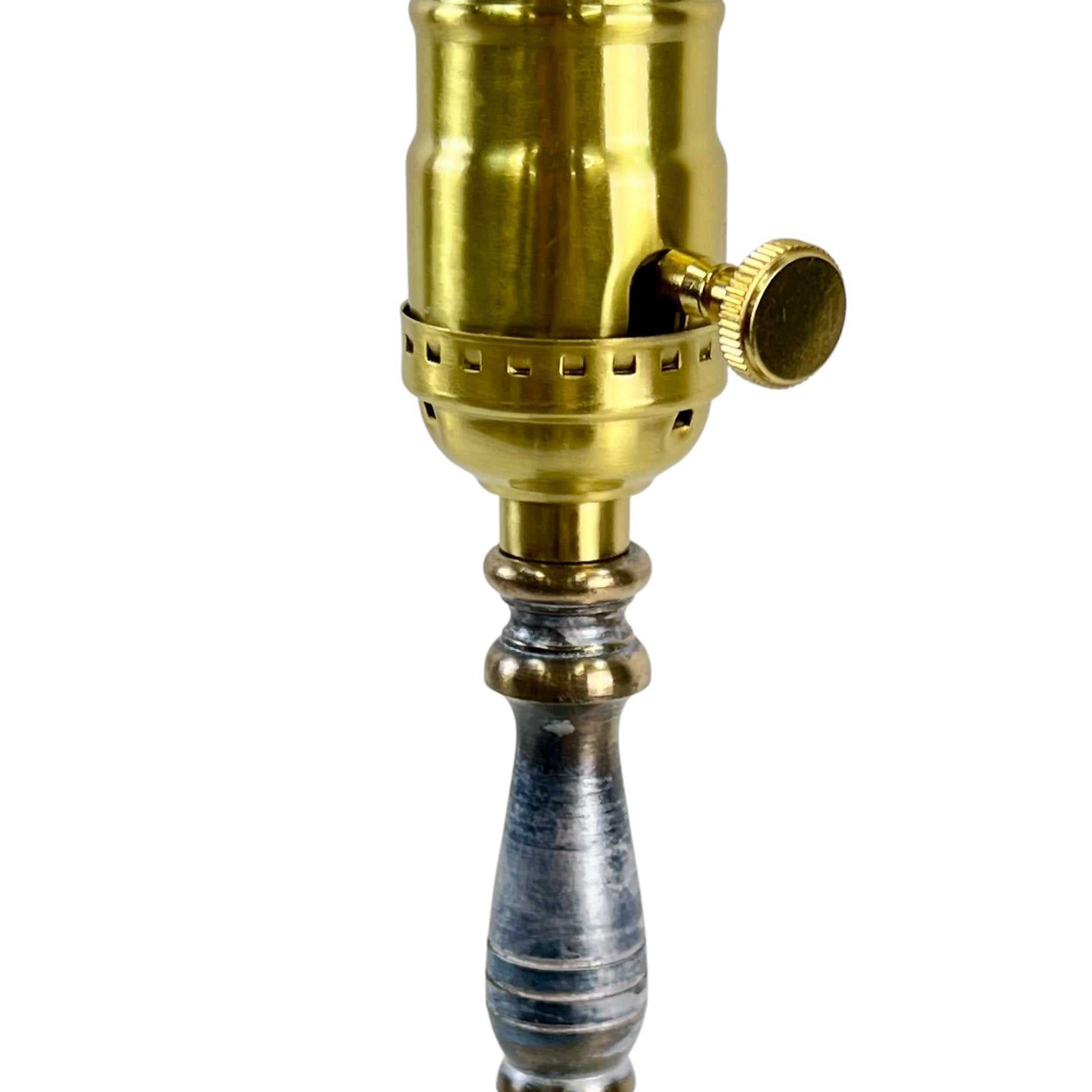 Decorative lamp with brass fitting and metal base on a white background