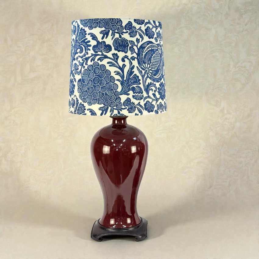 Lamp with a decorative blue and white lampshade on a beige background