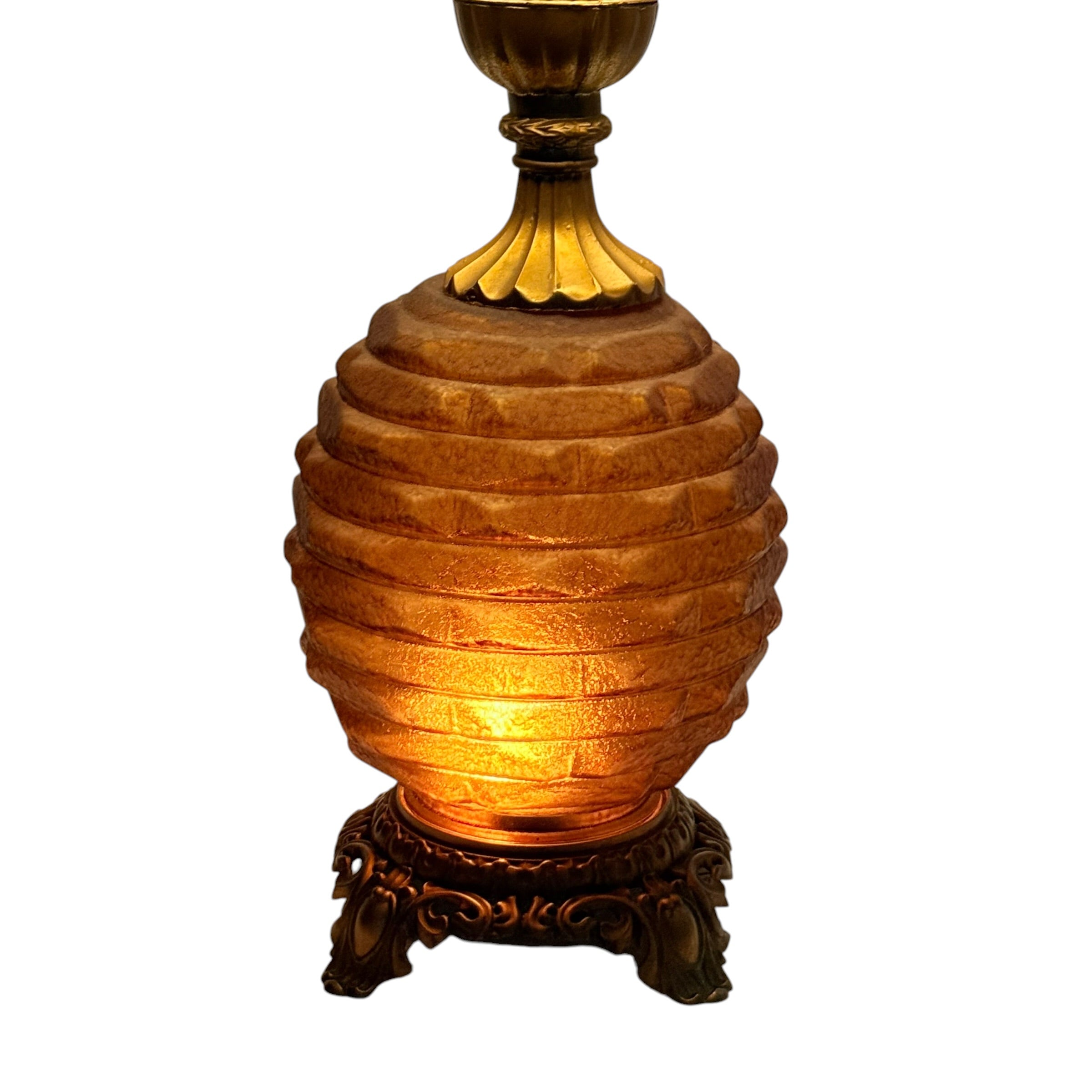 A decorative table lamp with a ribbed amber-brown glass or acrylic body, a dark ornate base, and a matching dark top finial, shown against a plain white background.