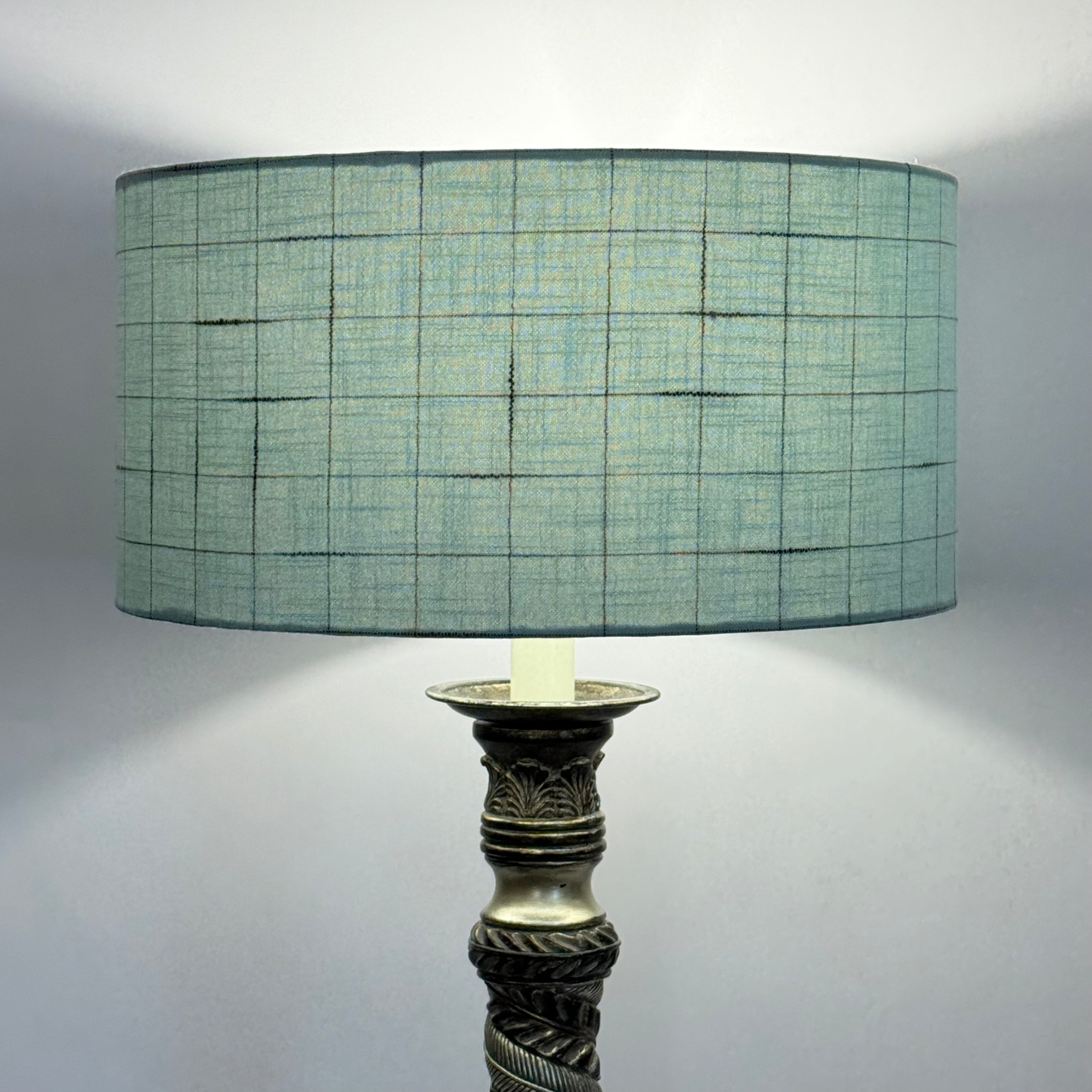 Lamp with a textured green shade on a white background