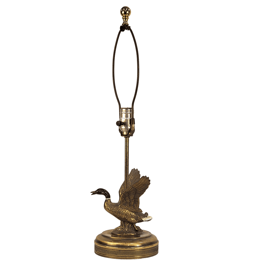 A vintage-style table lamp featuring a bronze goose figurine on a matching round base, with a dark cord arm and gold-toned finial, isolated on a white background.