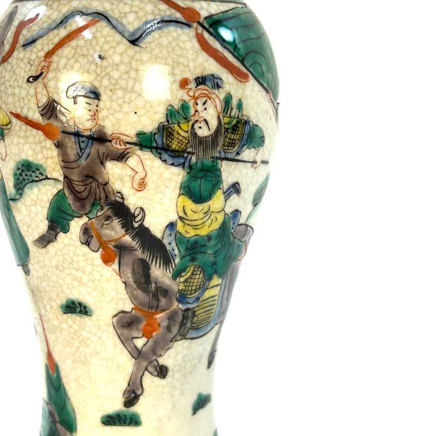 Close-up of a ceramic vase featuring a cream-colored glaze with a crackle finish and hand-painted Chinese-style figures in green, brown, and orange.