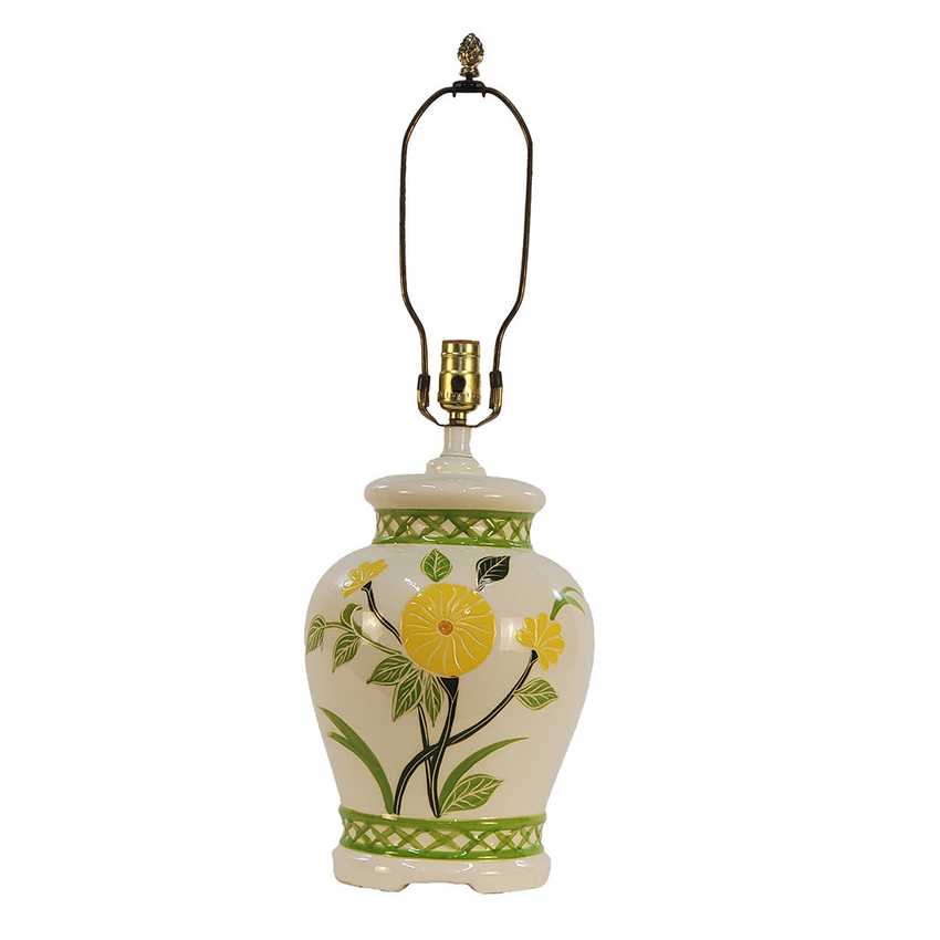 A ceramic table lamp with a white body decorated with yellow lemon illustrations, green leaves, and green patterned bands. It features a dark metal neck and a brass-colored socket.