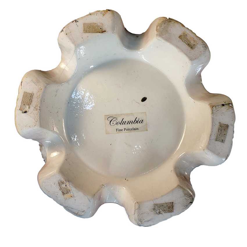 An antique scalloped ceramic dish or ashtray with a white glaze and a visible 'Columbia Fine Porcelain' label in the center, shown against a plain white background.