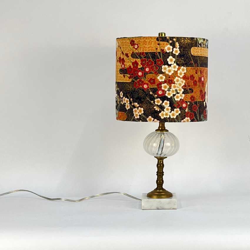 Decorative table lamp with a floral-patterned shade on a white background