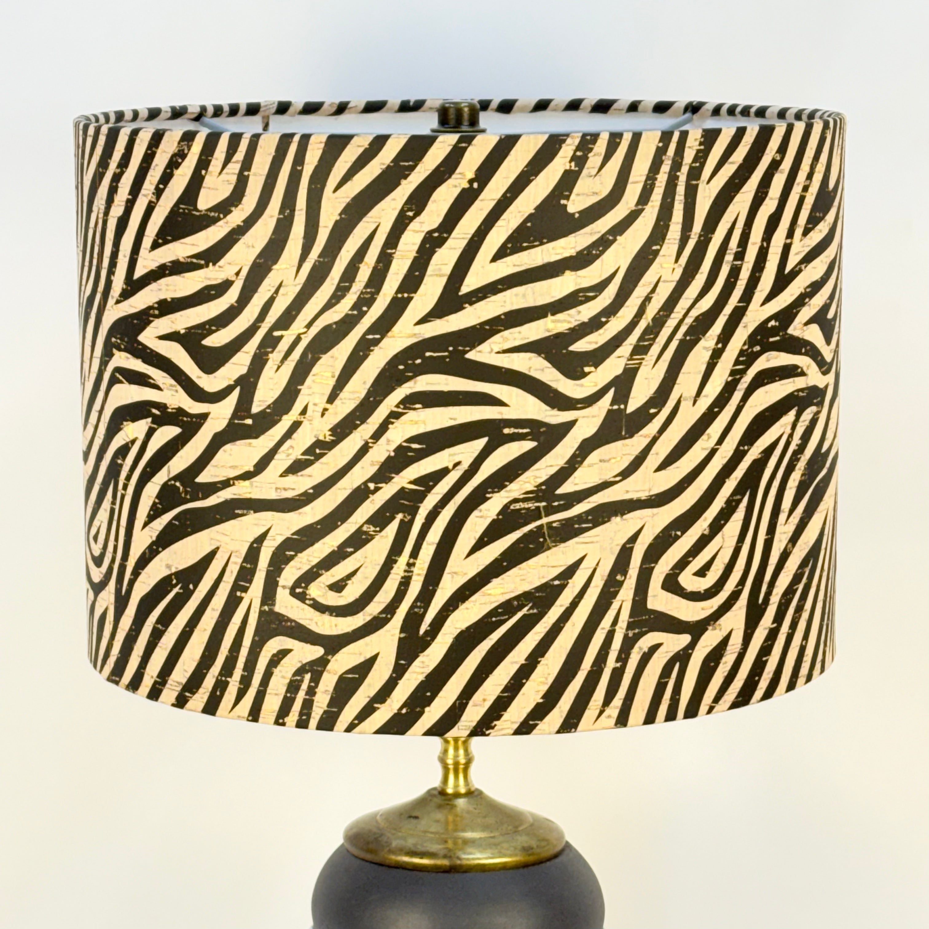 Lamp with zebra patterned shade on a plain background