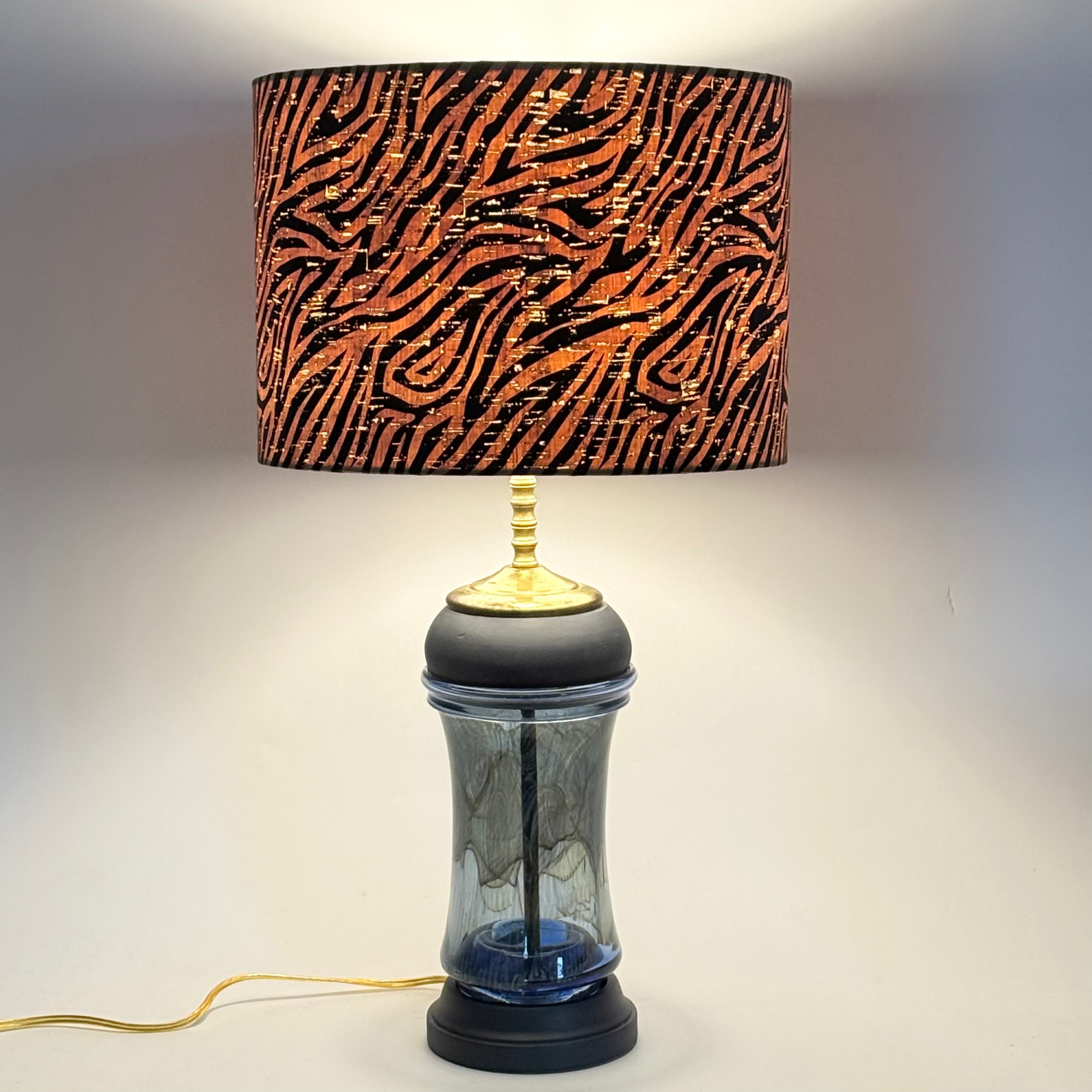 Lamp with a zebra pattern shade on a plain background